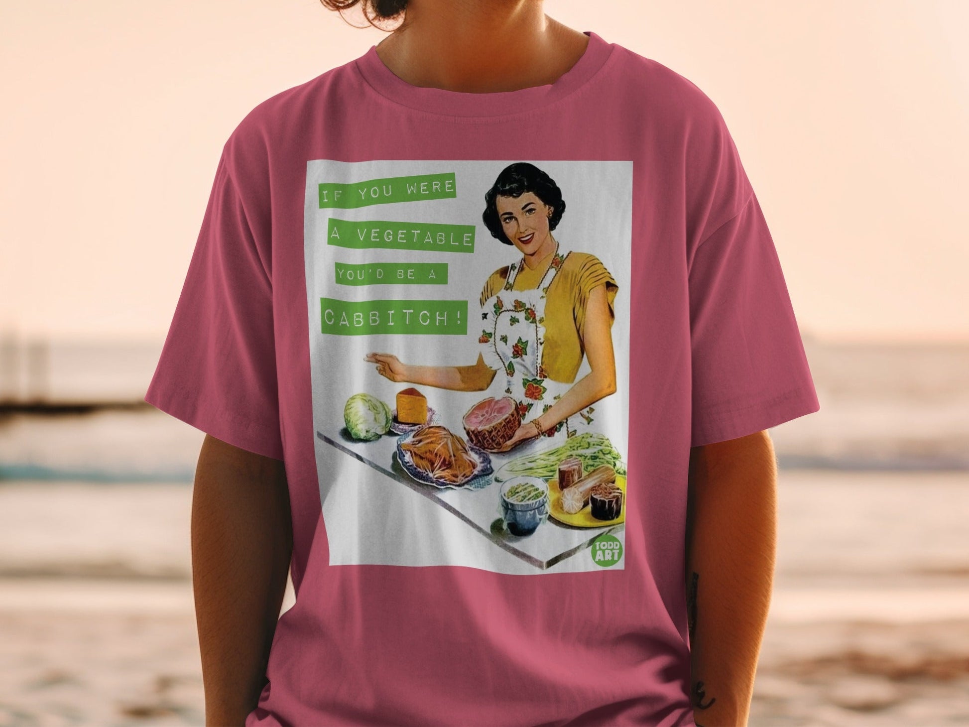 T-shirt with retro woman holding ham and vegetables, text "If you were a vegetable you'd be a cabbitch."