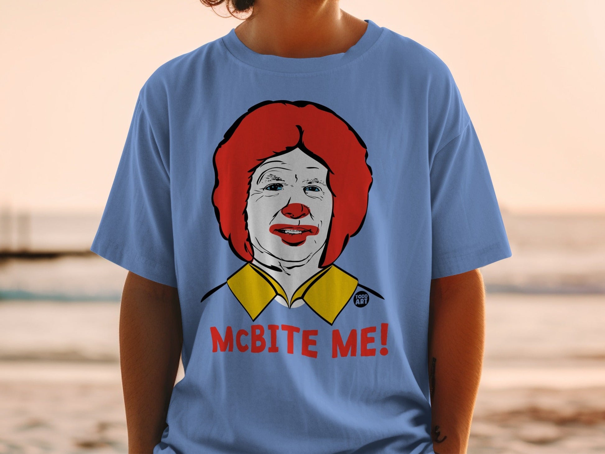 Blue t-shirt with cartoon Ronald McDonald face and "McBite Me!" text.