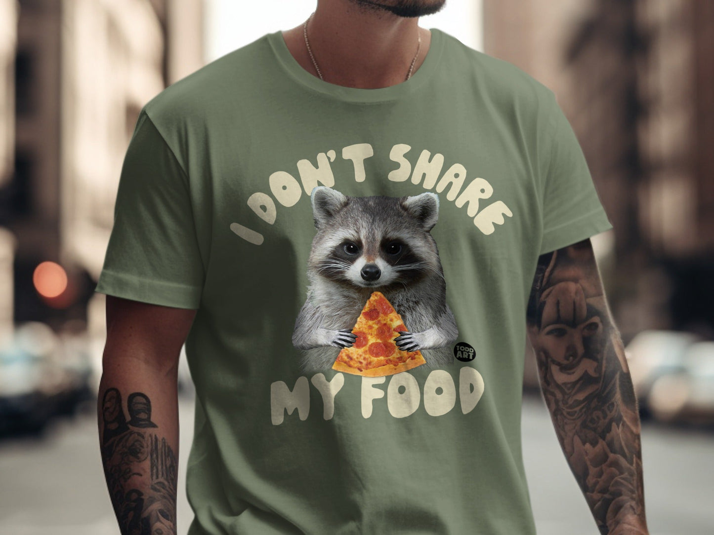 Green t-shirt with raccoon holding pizza and text "I DON'T SHARE MY FOOD".
