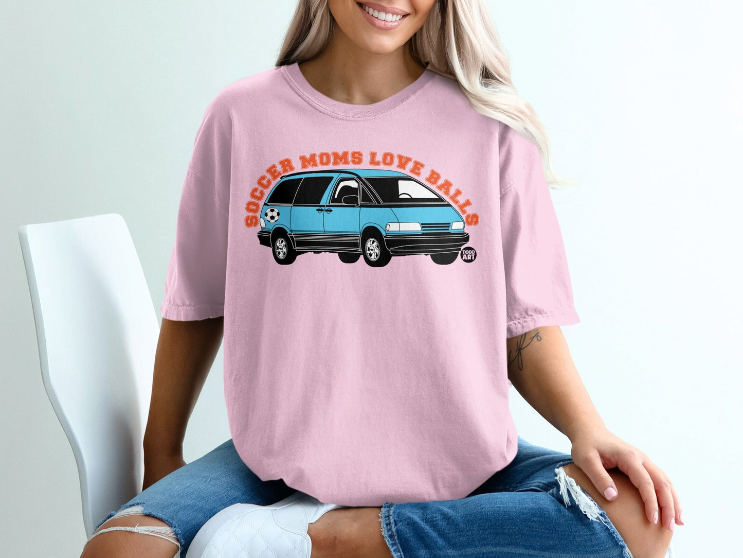 Pink t-shirt with graphic of blue minivan and text "Soccer Moms Love Balls".