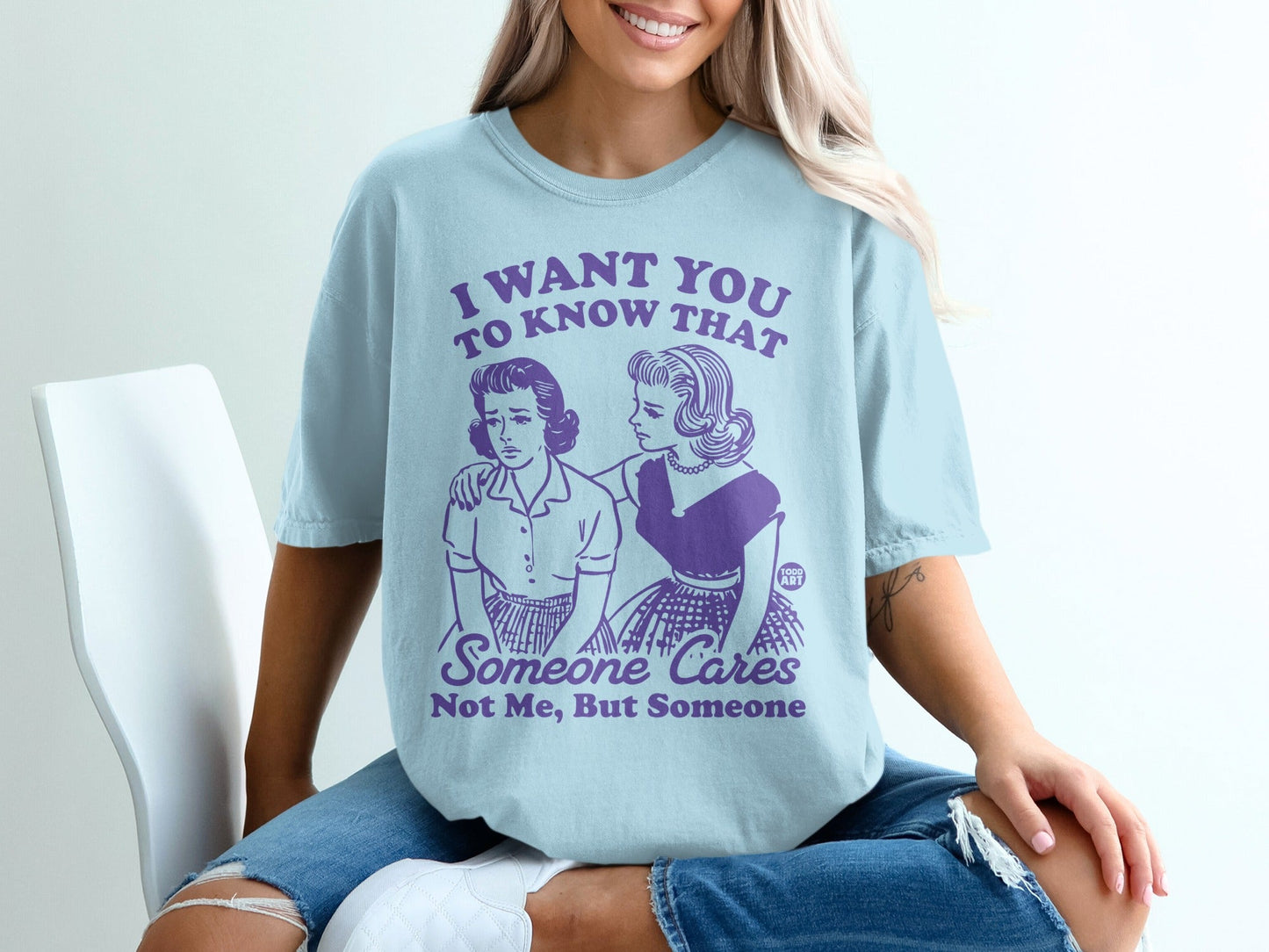 Light blue t-shirt with retro illustration and text about someone caring.
