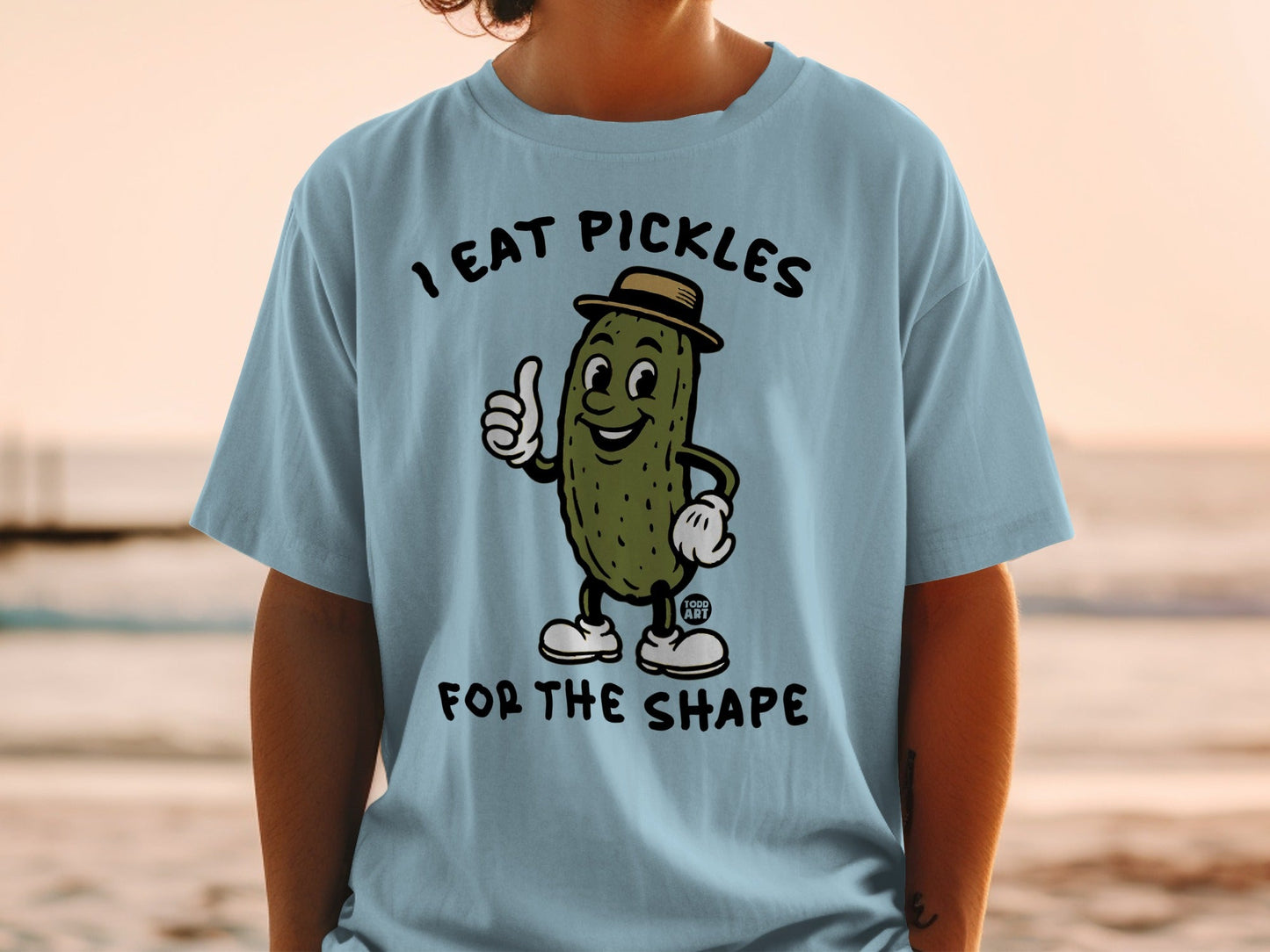 Light blue t-shirt with cartoon pickle wearing a hat giving a thumbs up.