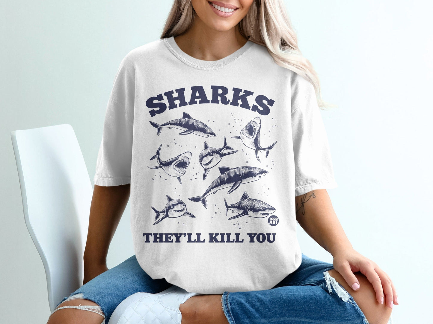 T-shirt with "SHARKS THEY'LL KILL YOU" text and cartoon shark illustrations.