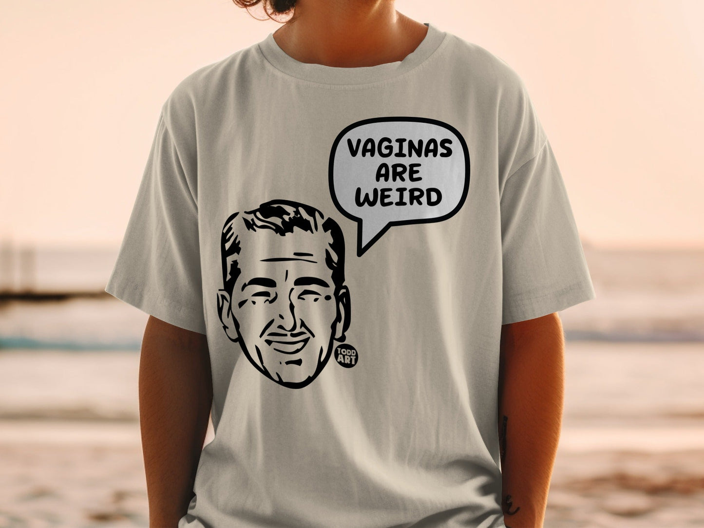Light gray t-shirt with cartoon man's head and "Vaginas are weird" text.