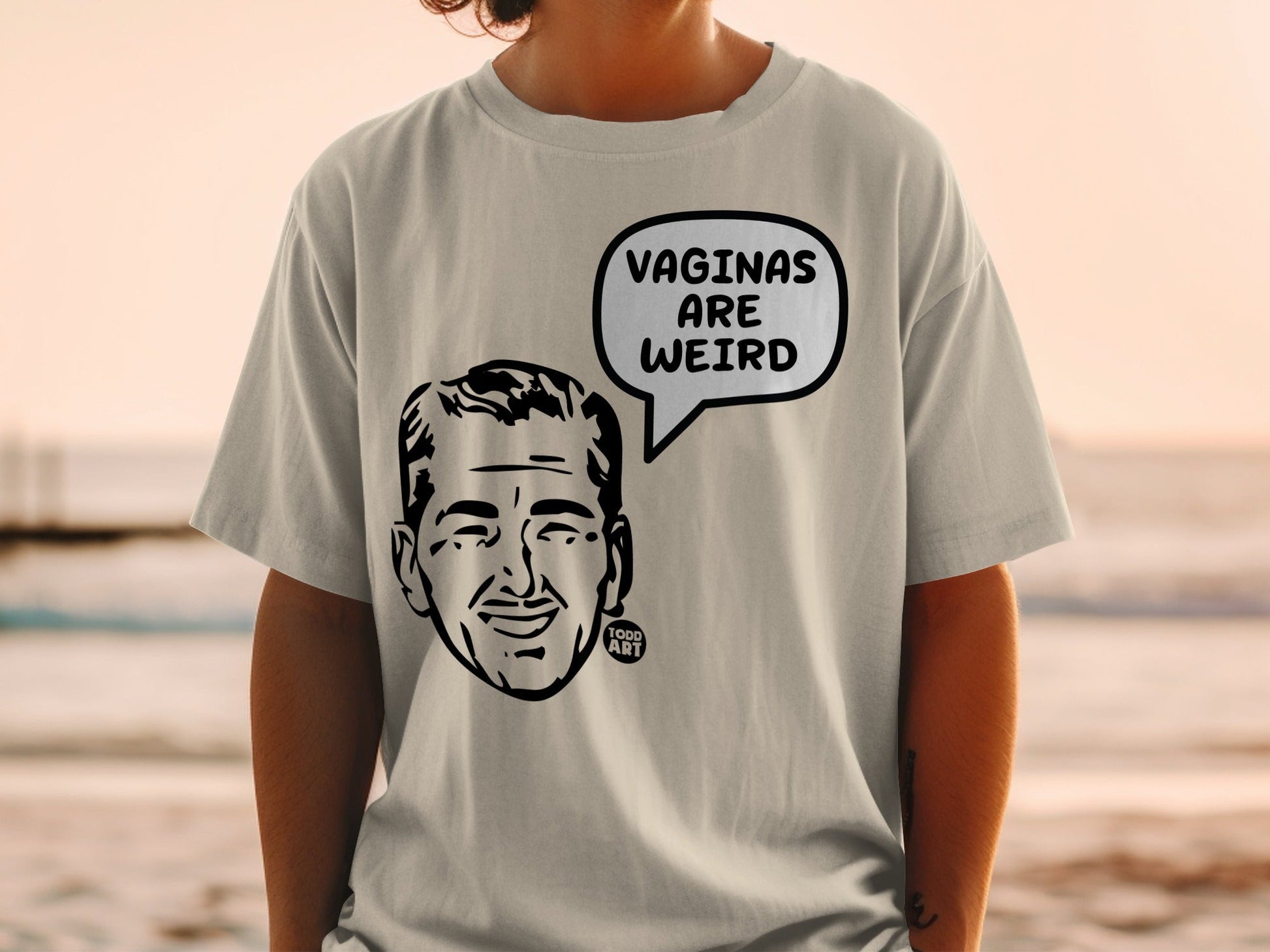Light gray t-shirt with cartoon man's head and "Vaginas are weird" text.