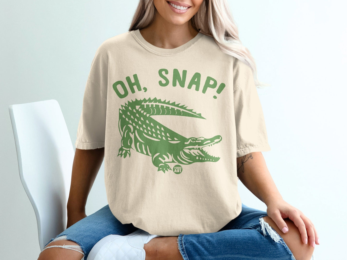 T-shirt with "OH, SNAP!" and alligator graphic in green on cream.