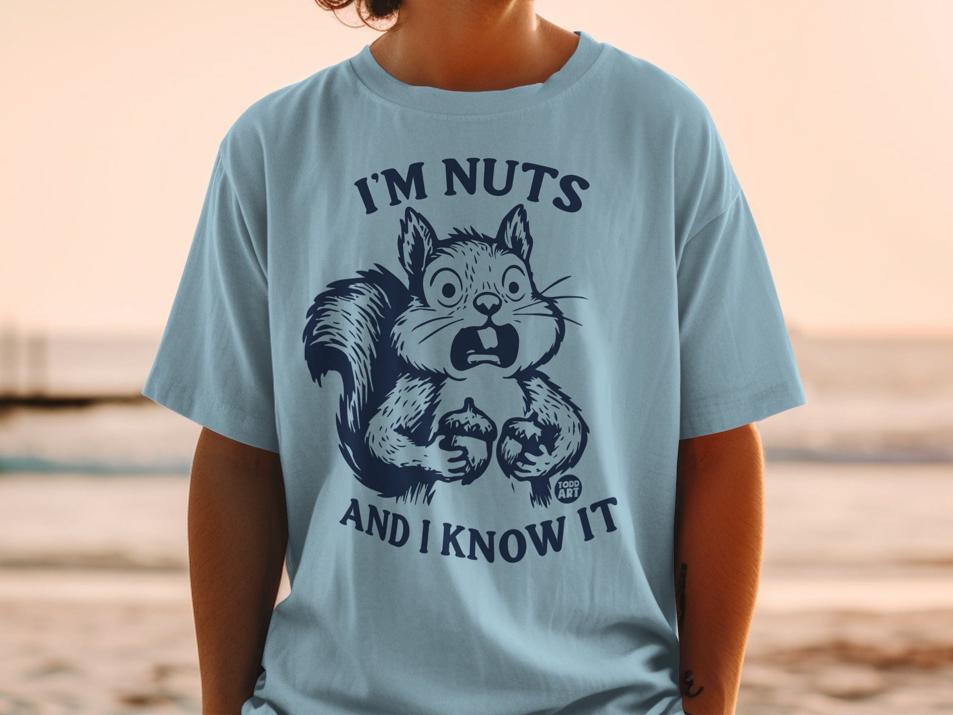 Light blue t-shirt with a surprised squirrel graphic and text "I'm nuts and I know it".