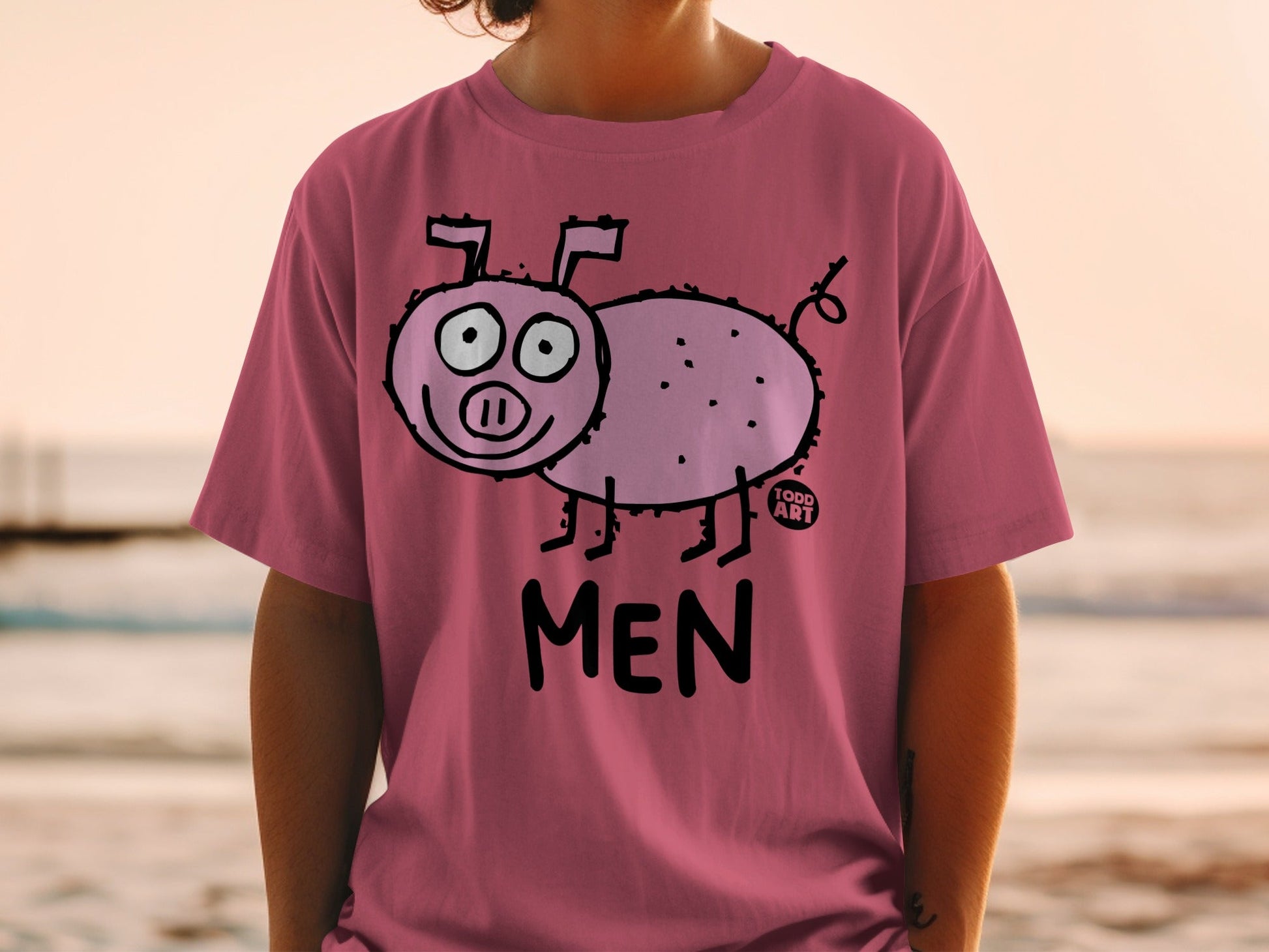 Pink t-shirt with a cartoon pig and "TODD ART" and "MEN" text.