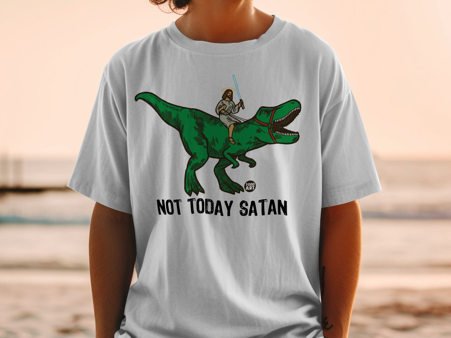 Jesus riding a T-Rex, holding a lightsaber, with "Not Today Satan" text.