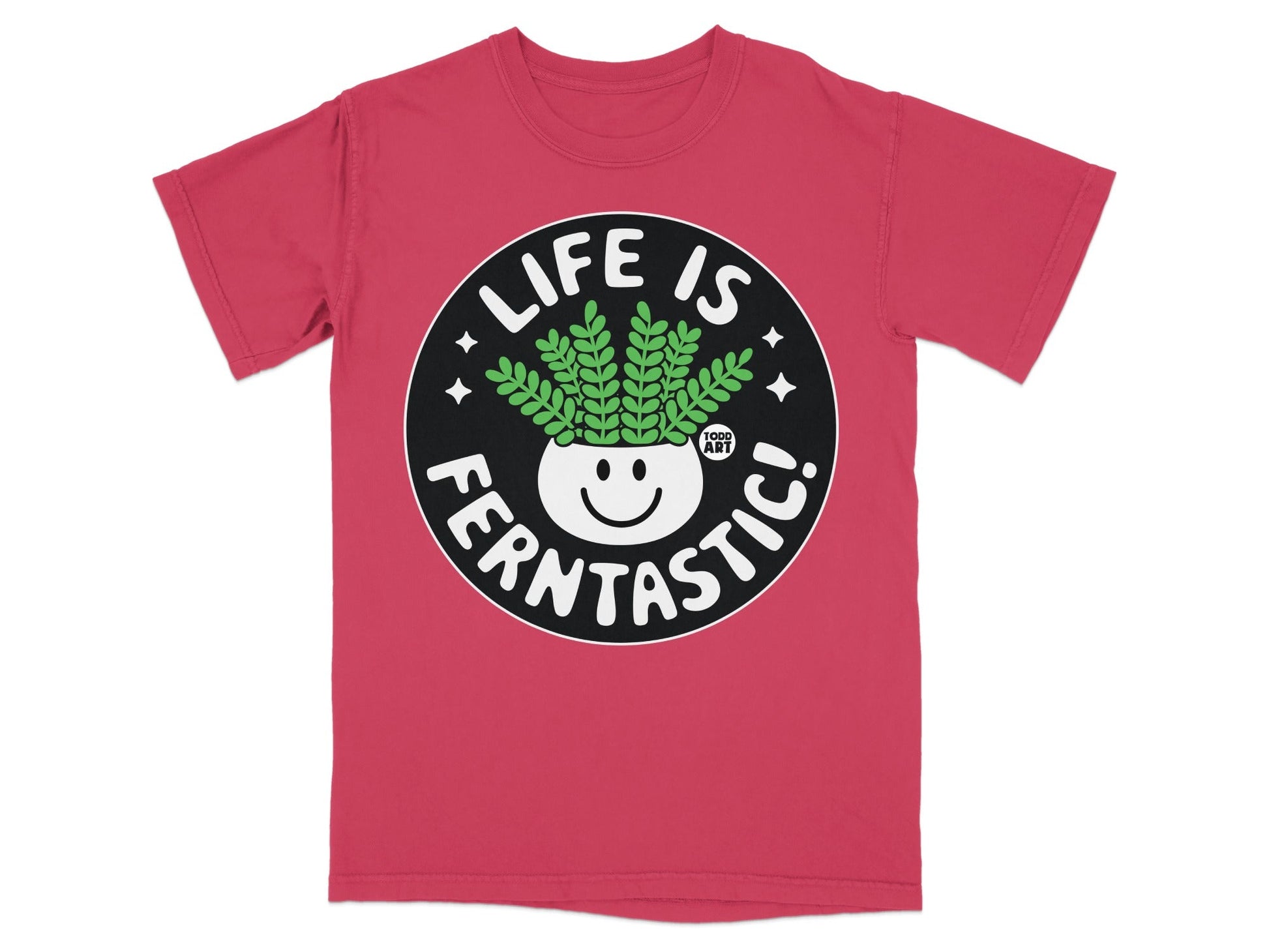 Pink t-shirt with a circular graphic featuring a smiling potted plant and "LIFE IS FERNTASIC!" text.