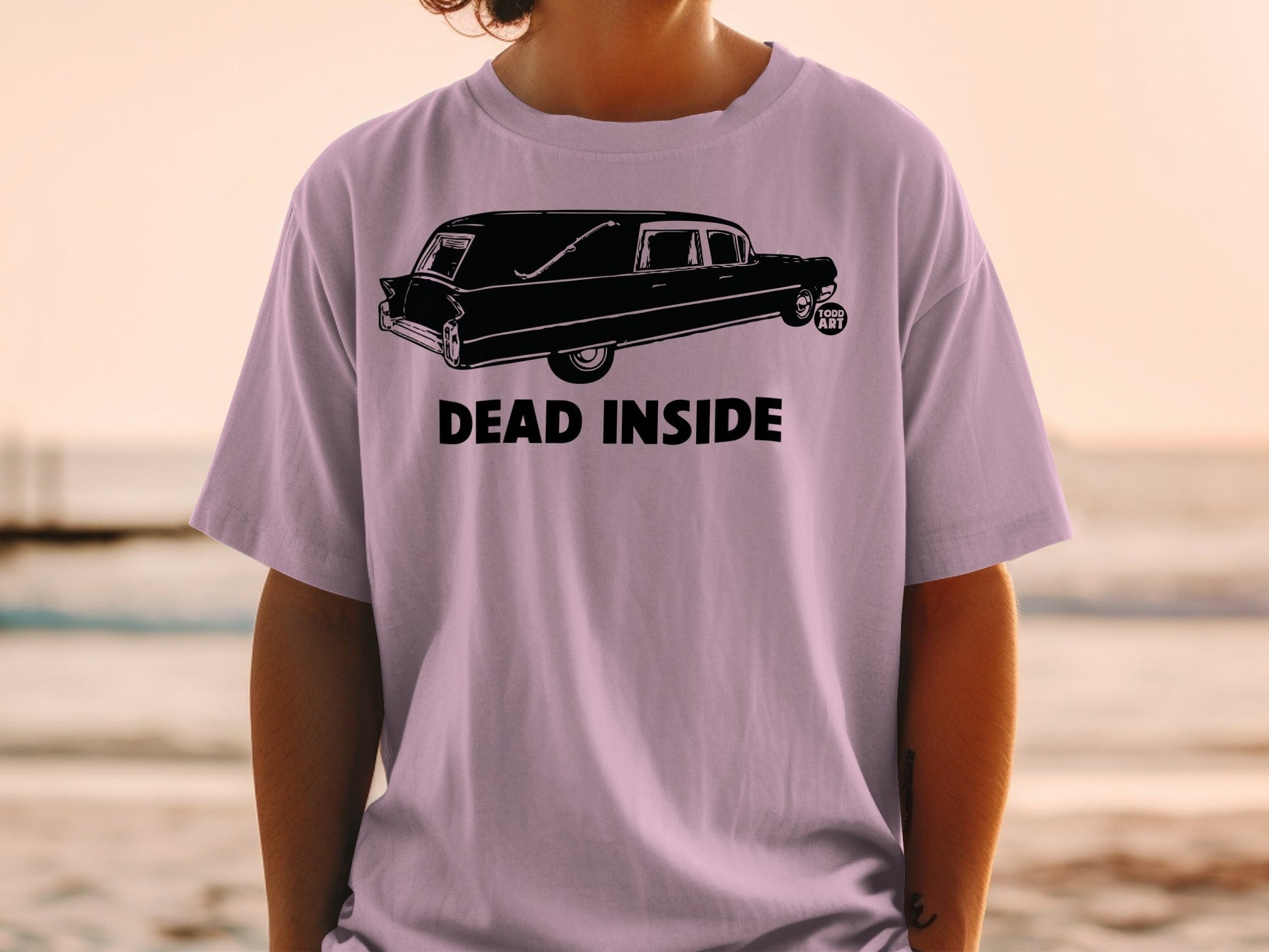 Black hearse with "DEAD INSIDE" text on a lavender t-shirt.