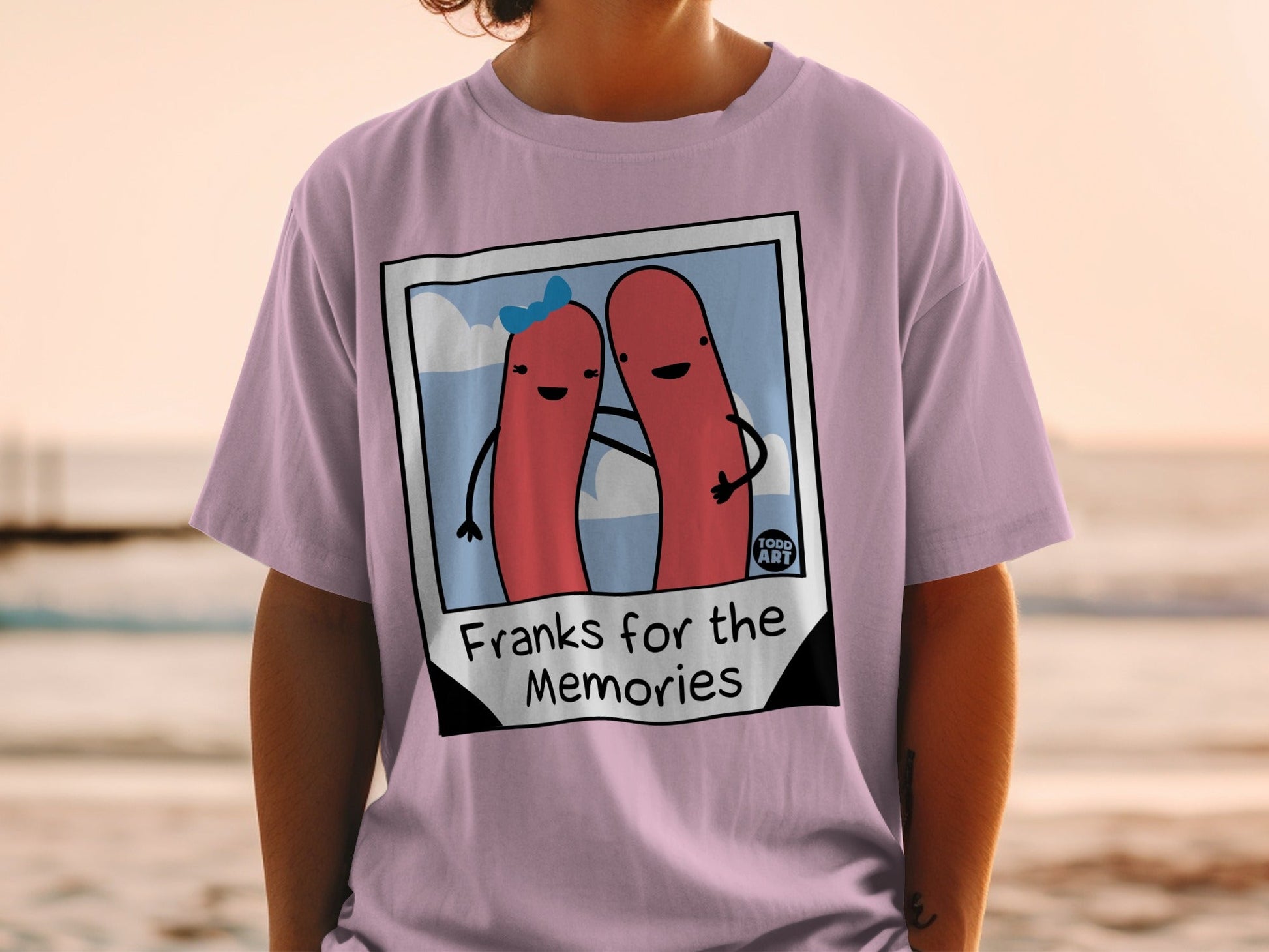 Lilac t-shirt with cartoon hot dogs and "Franks for the Memories" text.