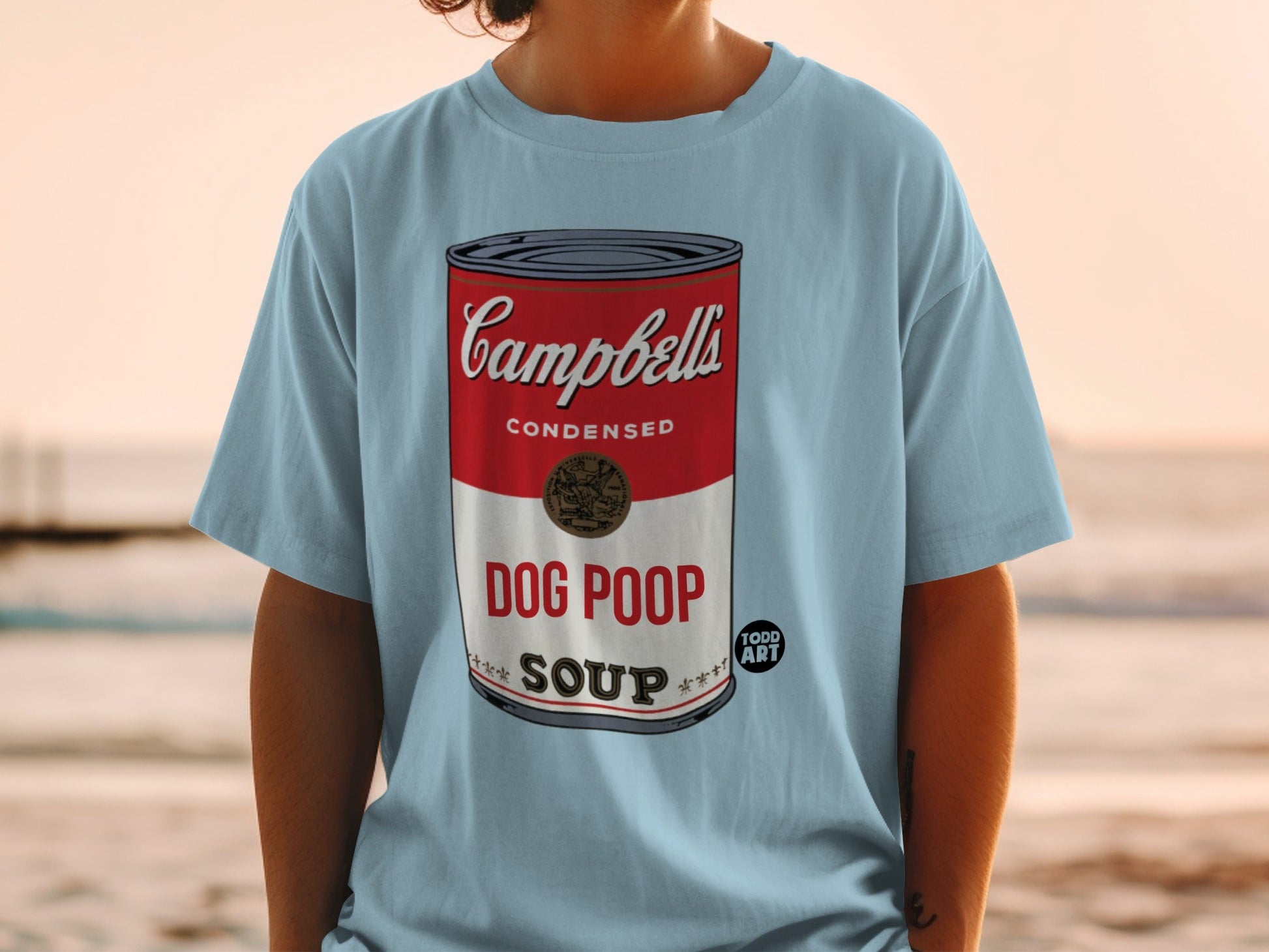 Light blue t-shirt with Campbell's condensed soup can design modified to say "DOG POOP".