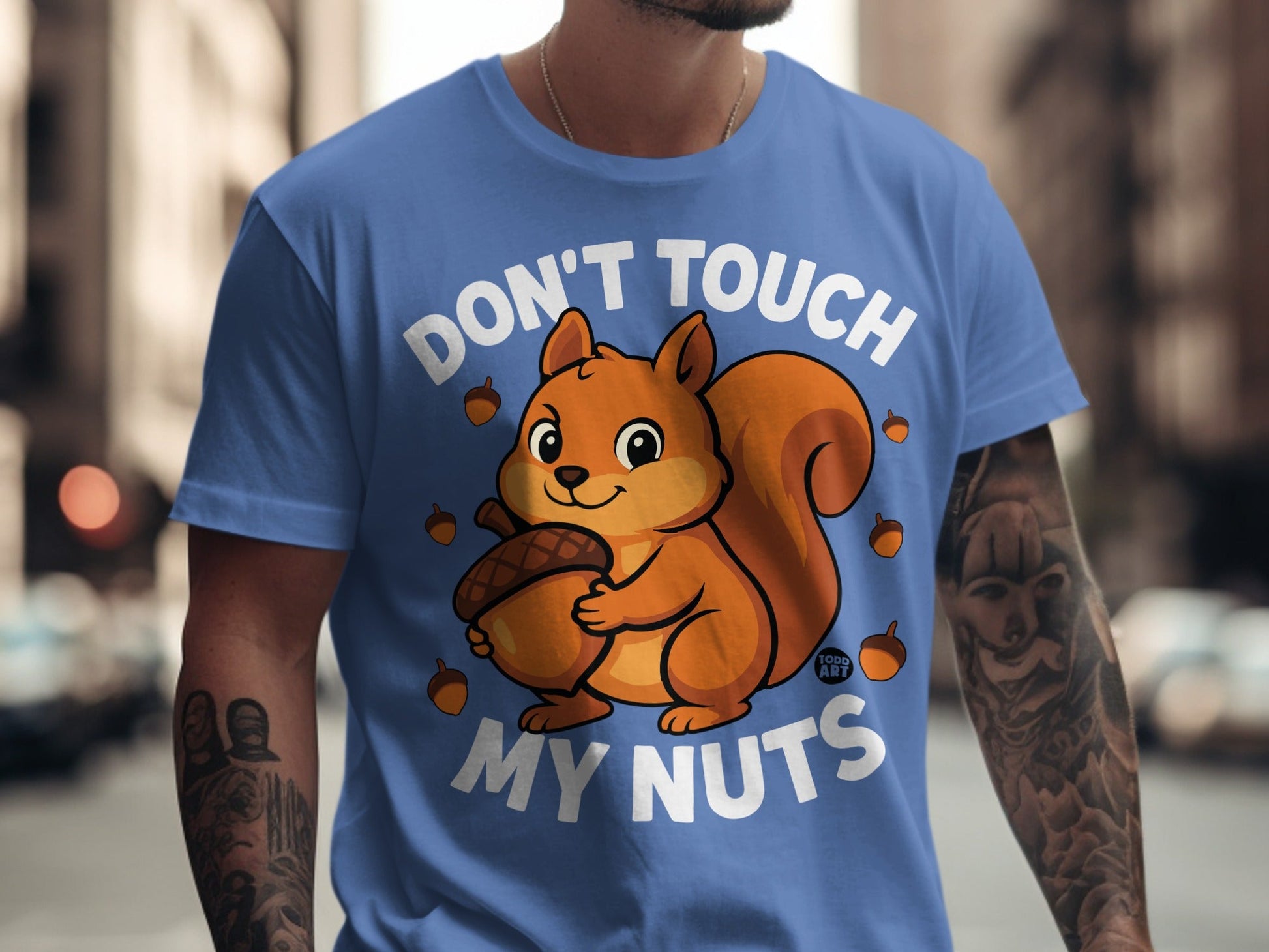 Blue t-shirt with a cartoon squirrel holding an acorn and the text "Don't Touch My Nuts".