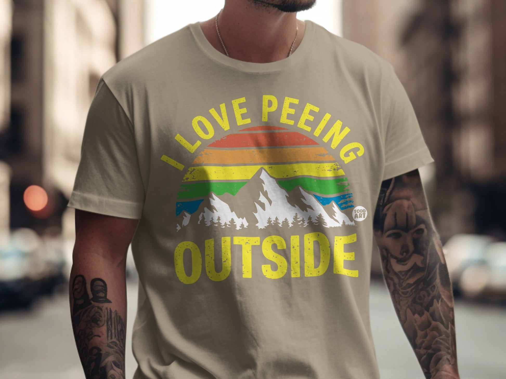 T-shirt with "I love peeing outside" text and mountain rainbow graphic.
