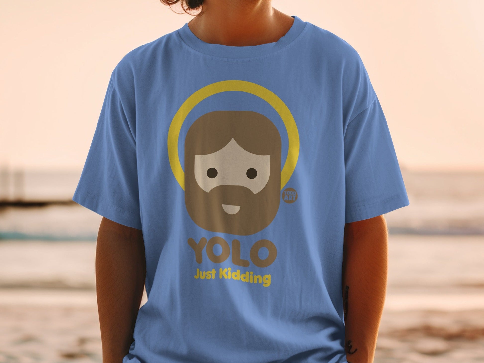 Blue t-shirt with "YOLO Just Kidding" and a cartoon haloed figure.