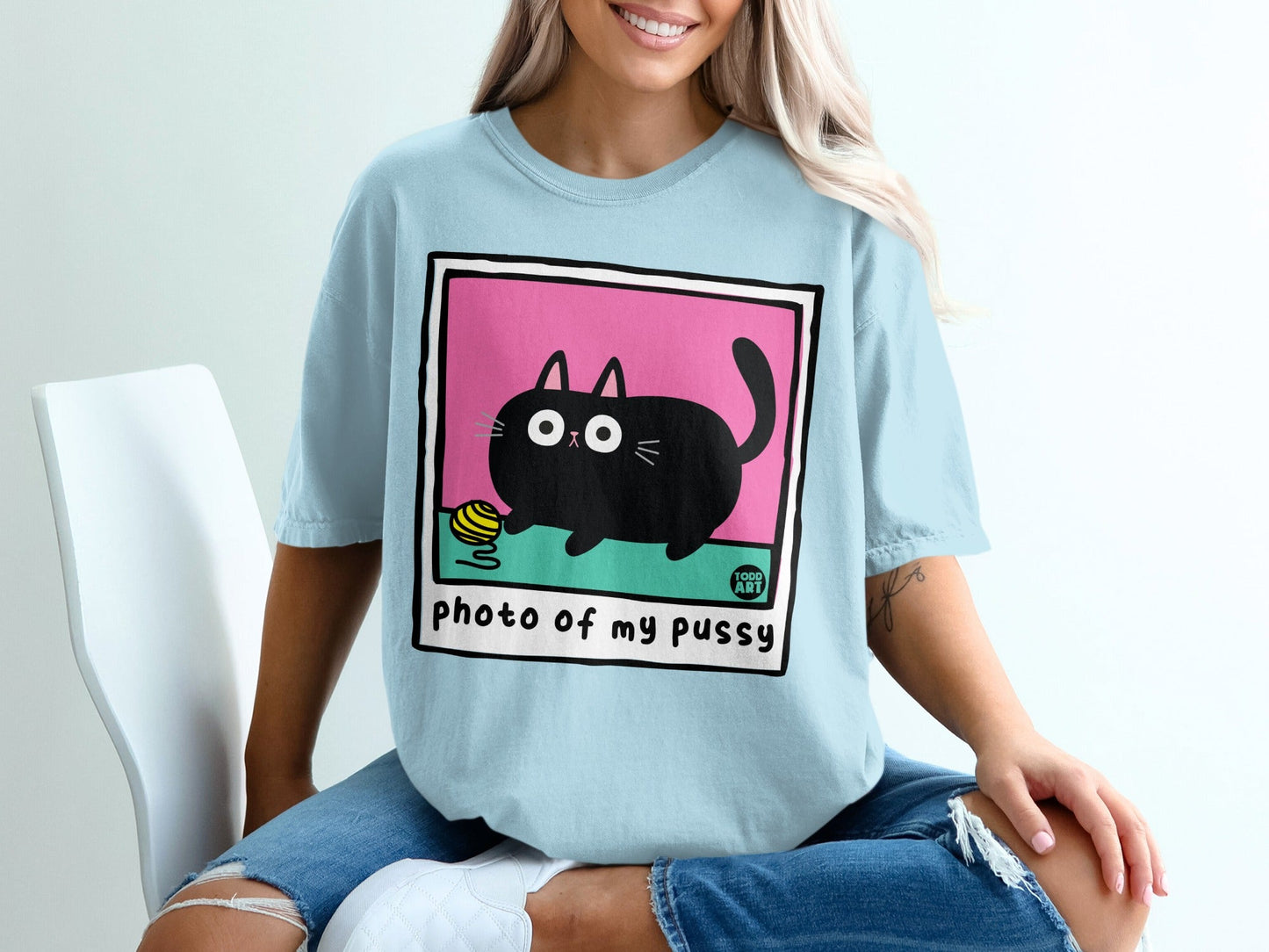 Black cat on pink background with yarn, text "photo of my pussy".