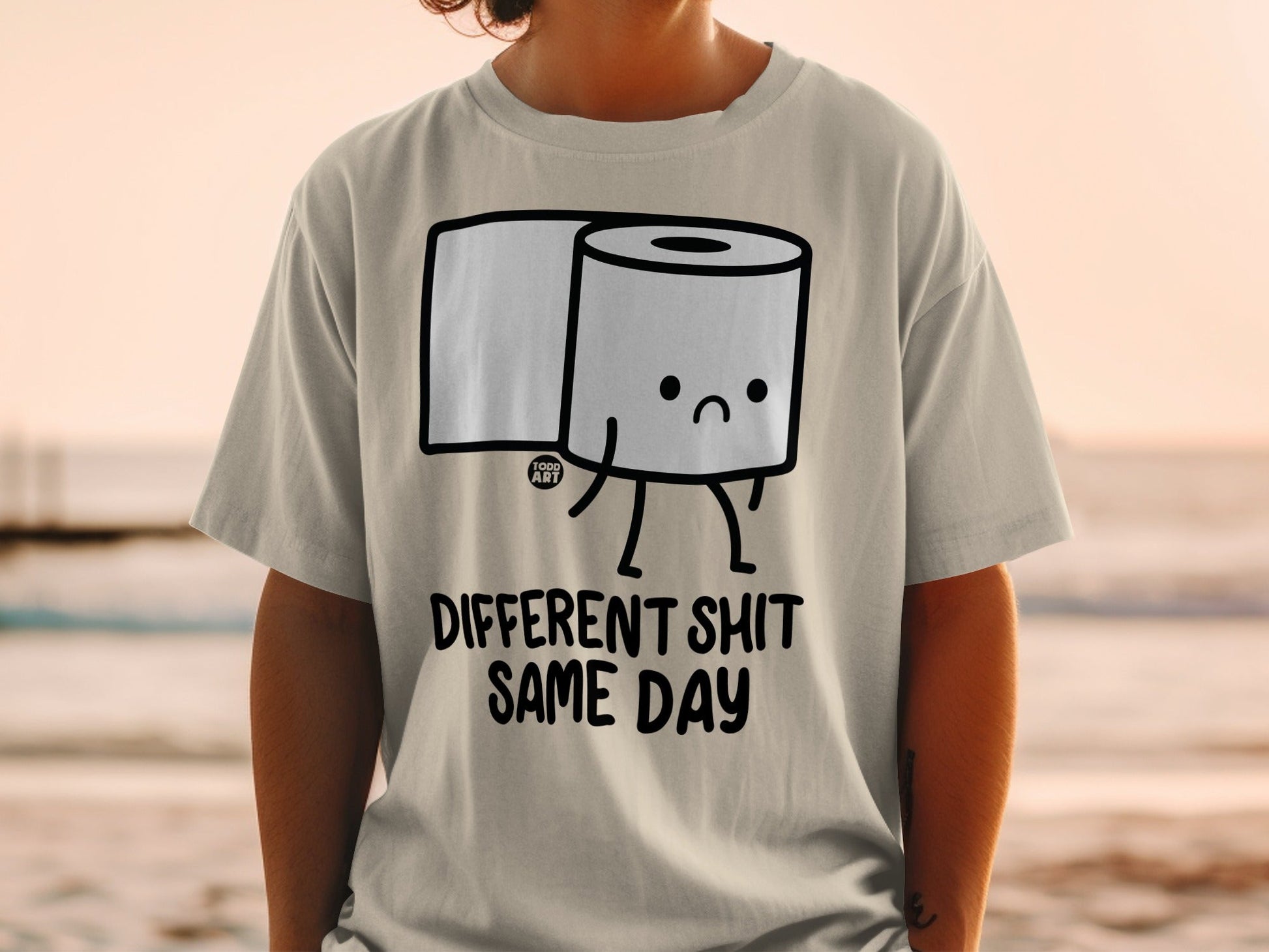 T-shirt with cartoon toilet paper roll and text "Different Shit Same Day".