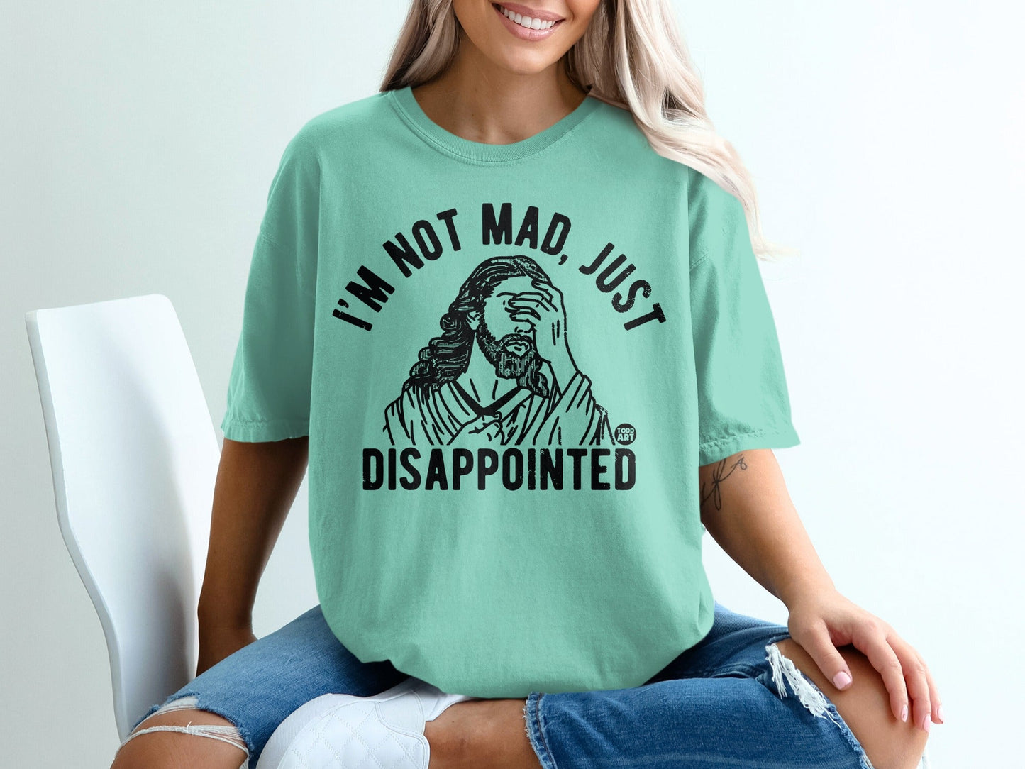 Mint green t-shirt with "I'M NOT MAD, JUST DISAPPOINTED" and Jesus graphic.