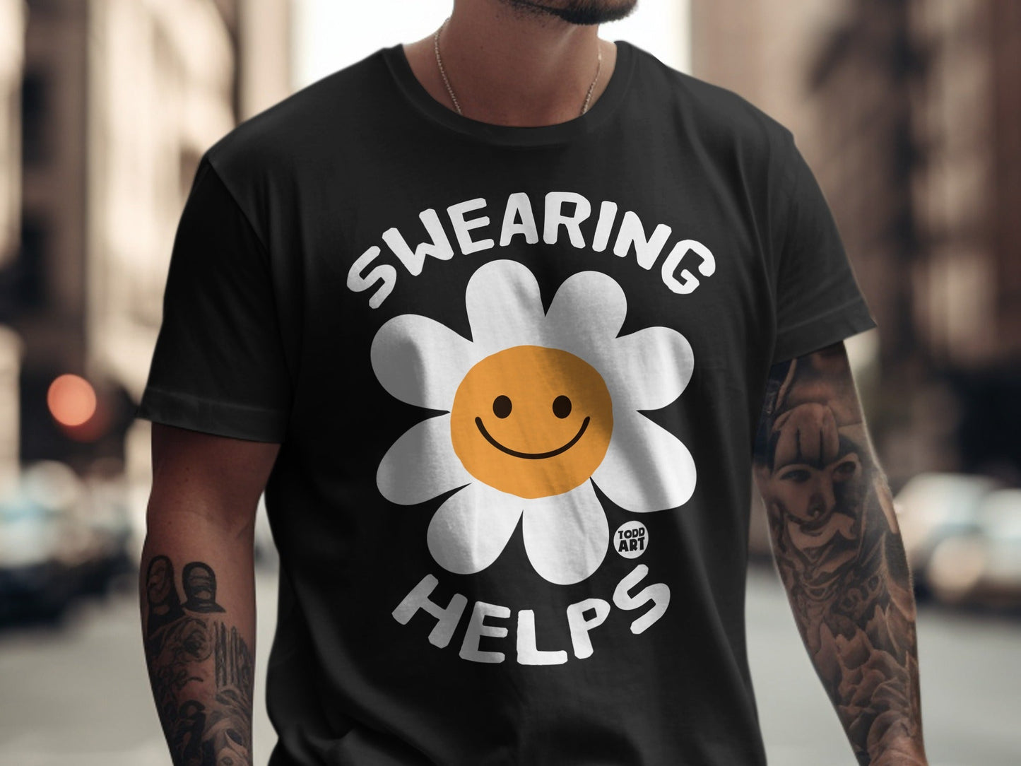 Black t-shirt with "SWEARING HELPS" and a smiley face flower logo.
