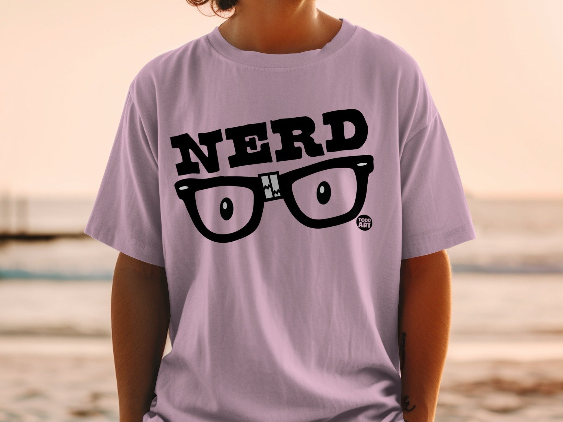 Light purple t-shirt with "NERD" text and eyeglasses graphic.
