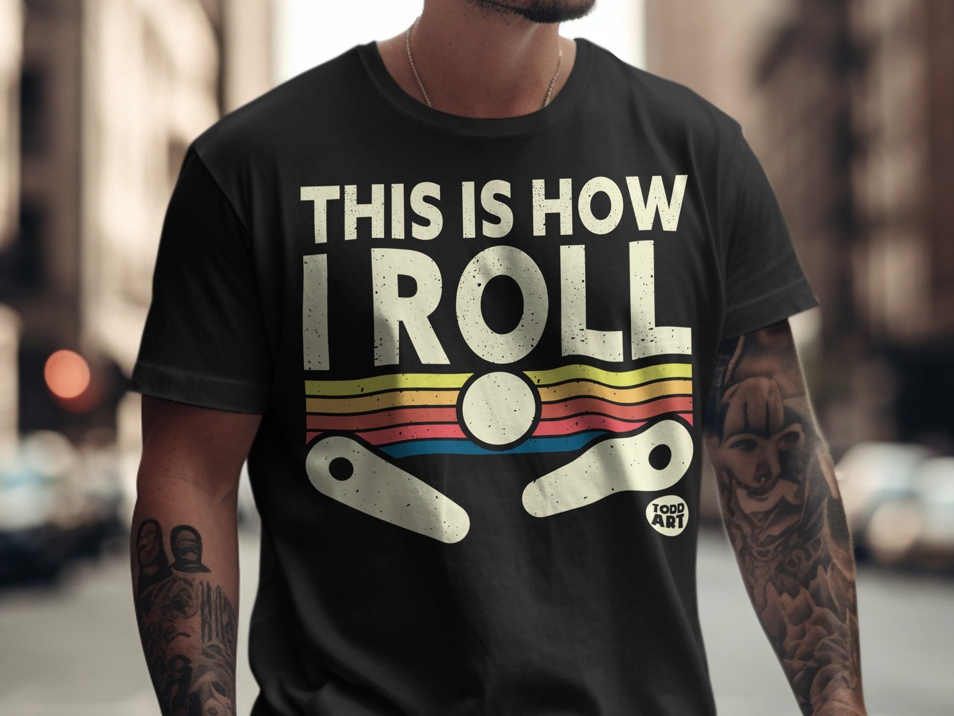 Black t-shirt with "THIS IS HOW I ROLL" text and pinball graphic.