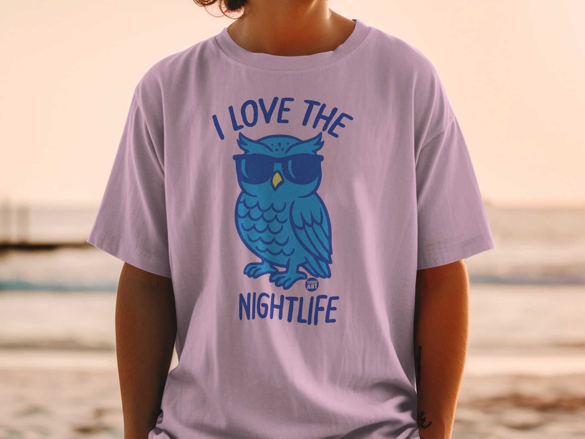 Illustration of a blue owl wearing sunglasses on a purple t-shirt.
