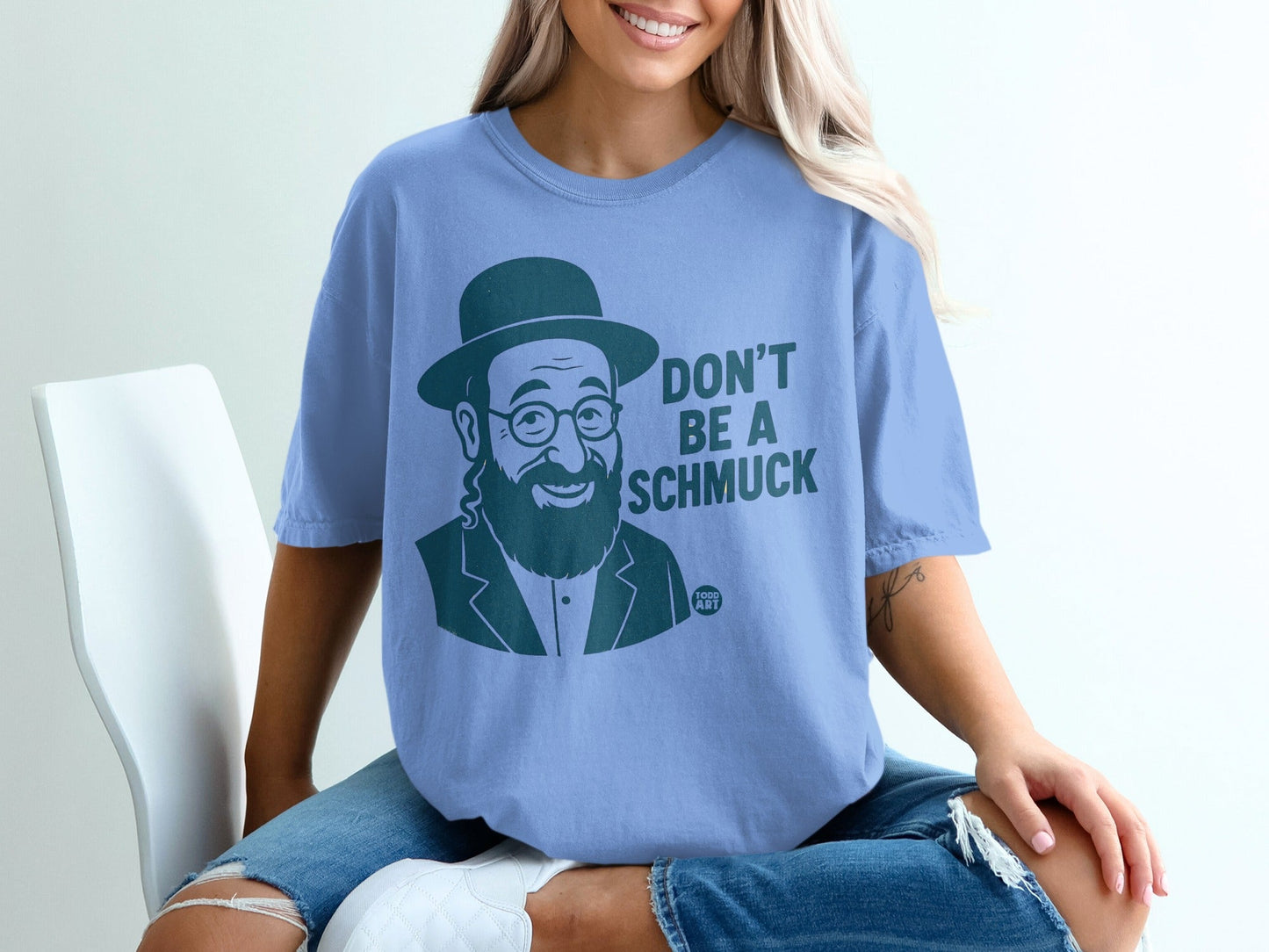 Blue t-shirt with graphic of a man in a hat, saying "DON'T BE A SCHMUCK".