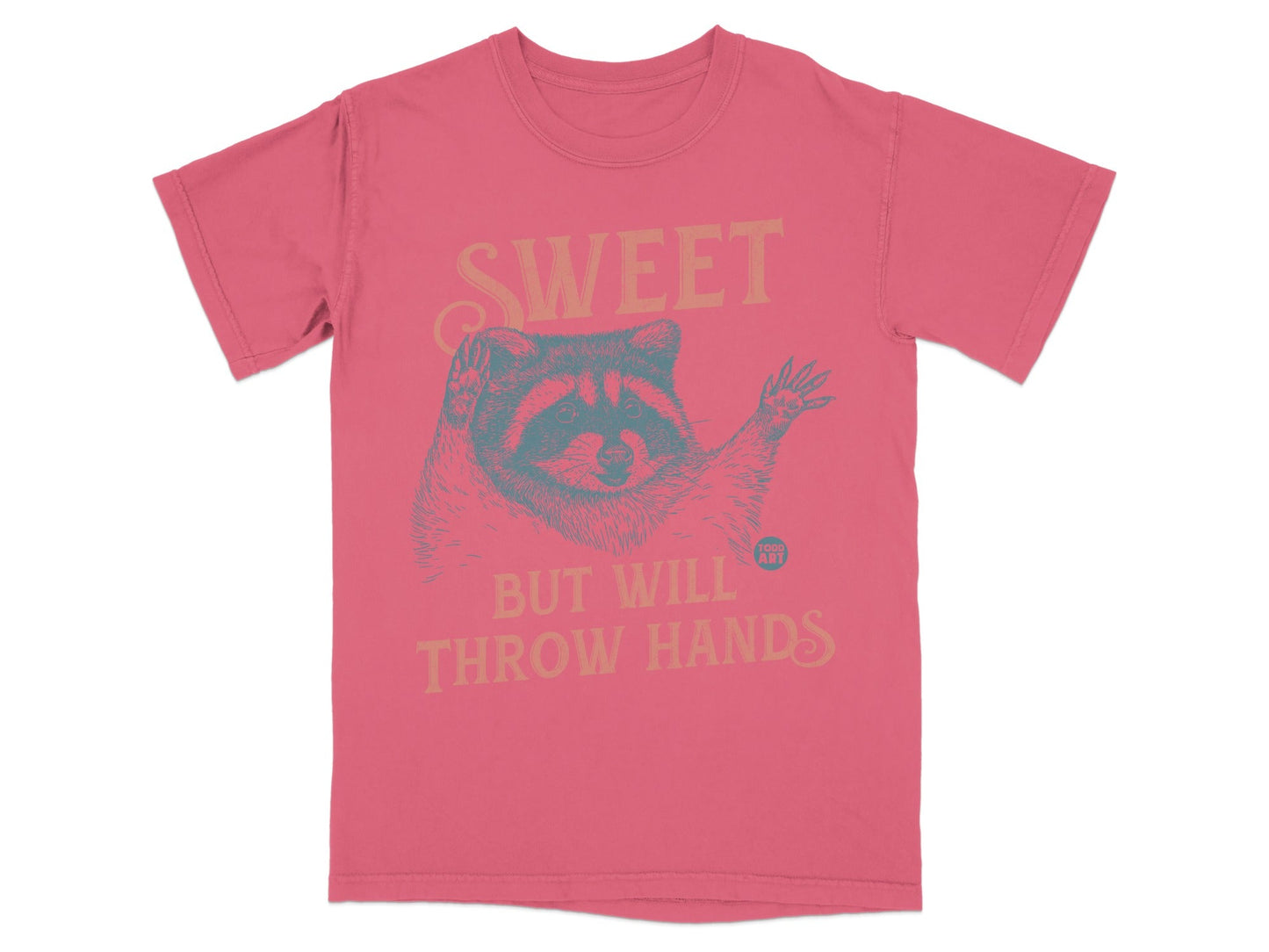 Pink t-shirt with raccoon graphic and "Sweet but will throw hands" text.