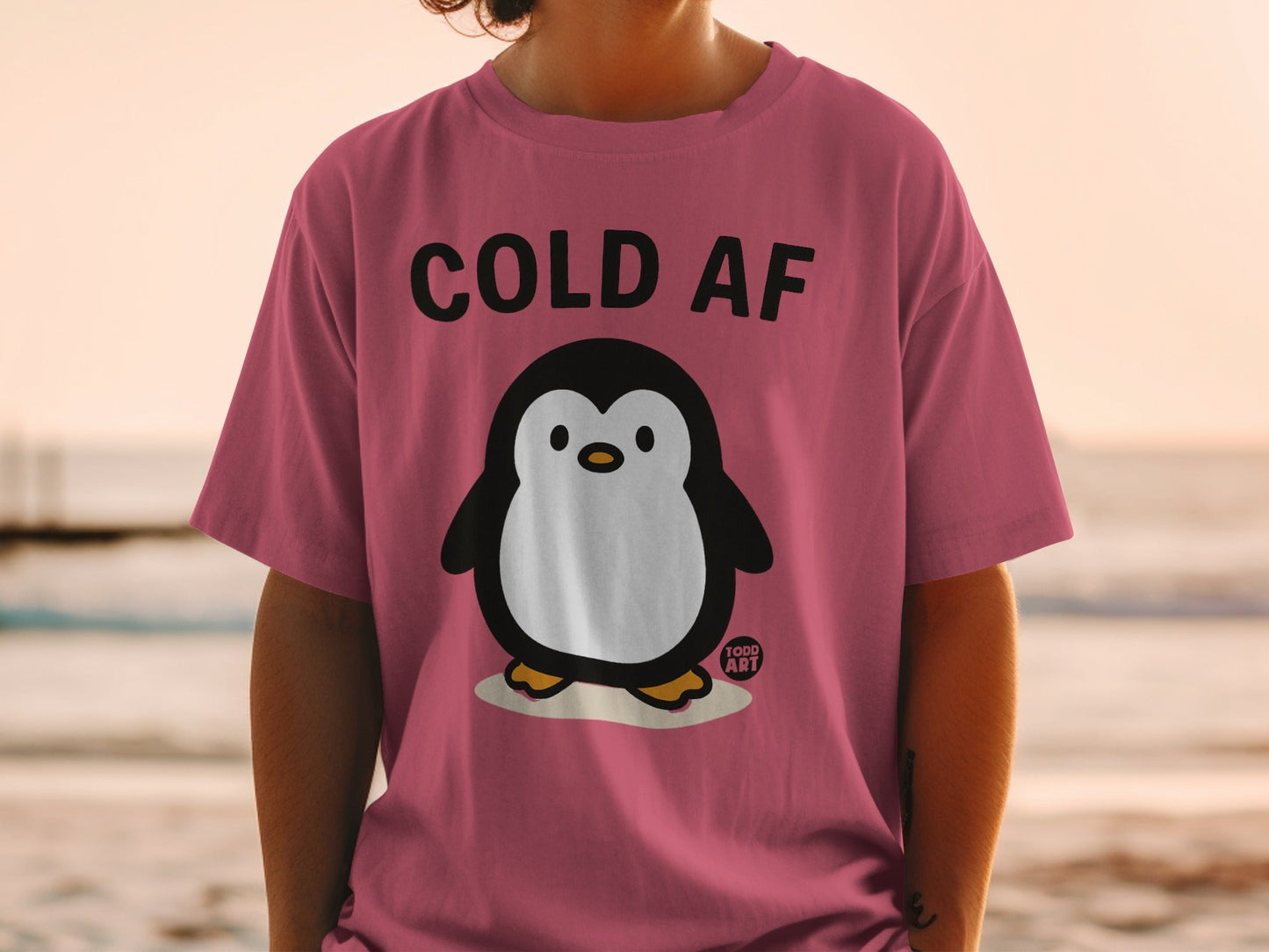 Pink t-shirt with a cartoon penguin and "COLD AF" text.