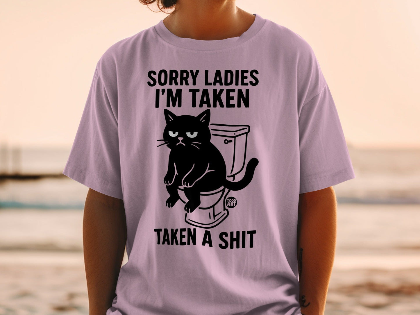 Black cat sitting on a toilet with text "SORRY LADIES I'M TAKEN TAKEN A SHIT".