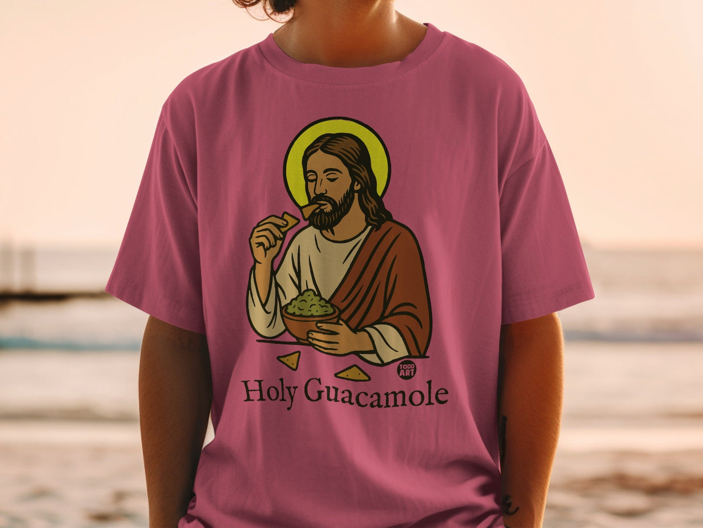 Pink t-shirt with Jesus eating guacamole and chips, "Holy Guacamole" text.