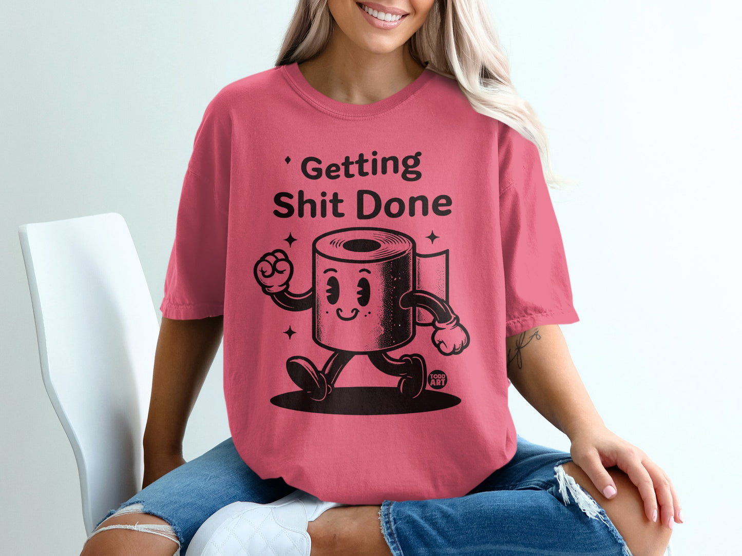 Pink t-shirt with cartoon toilet paper character saying "Getting Shit Done."