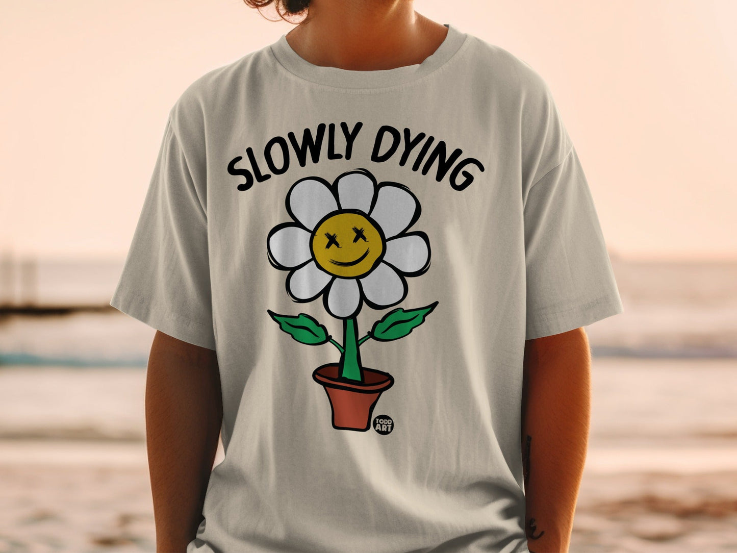 T-shirt with cartoon flower, "SLOWLY DYING" text, and flower pot.