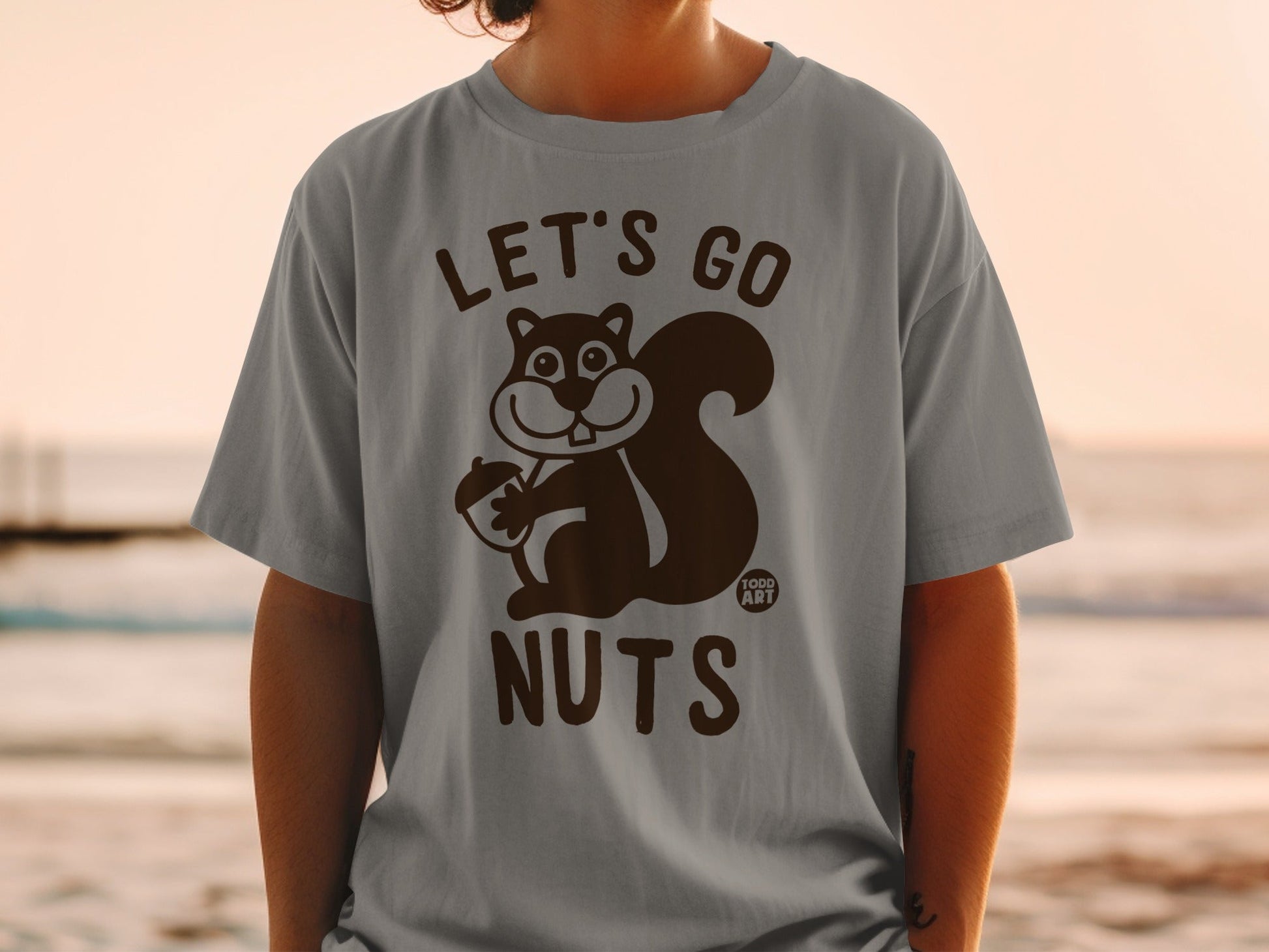 Gray t-shirt with cartoon squirrel holding acorn, "LET'S GO NUTS" text.