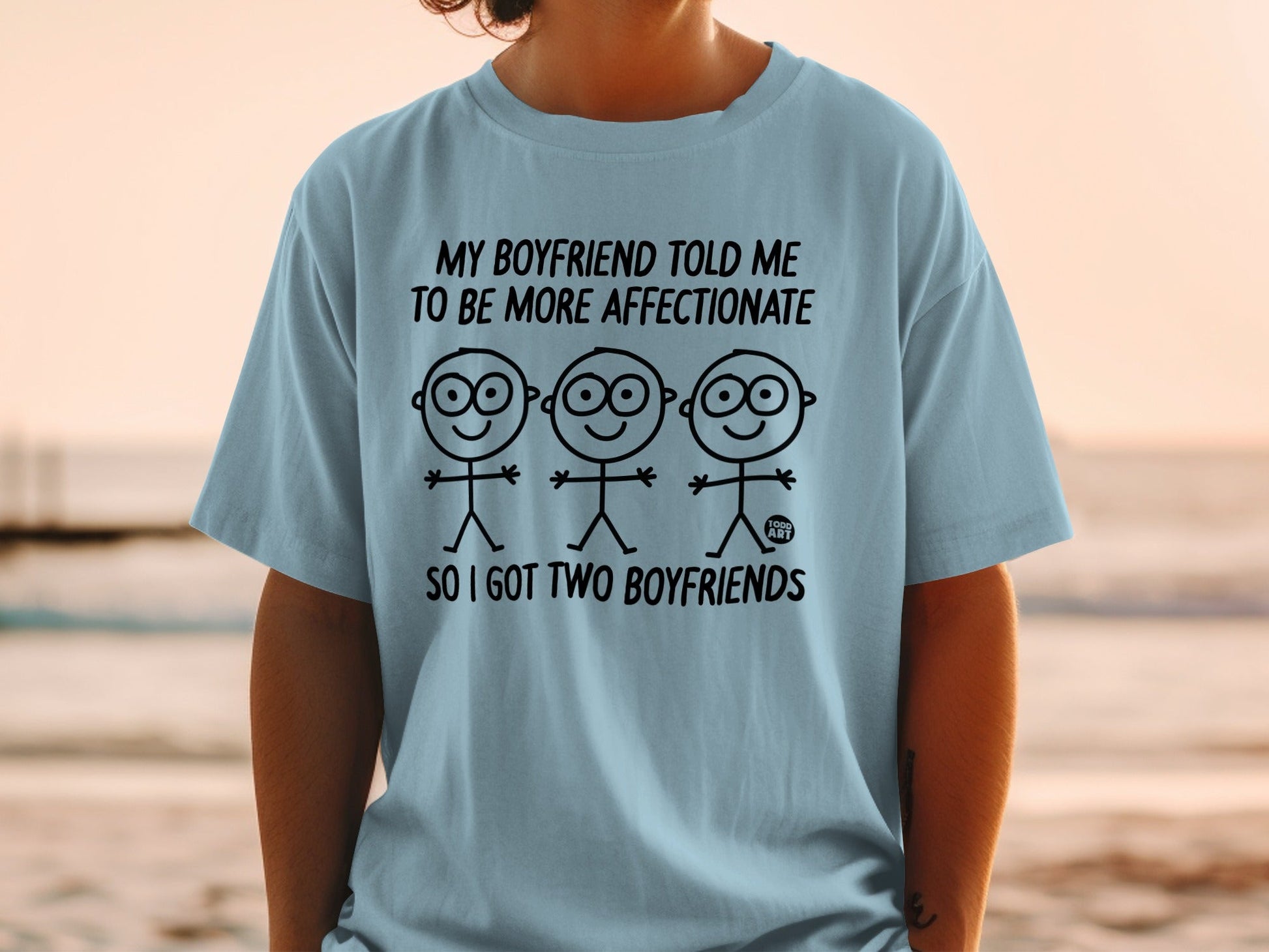 Light blue t-shirt with cartoon figures and "SO I GOT TWO BOYFRIENDS" text.