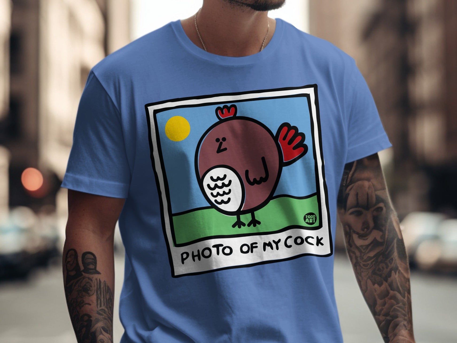 Blue t-shirt featuring a cartoon chicken illustration with "PHOTO OF MY COCK" text.