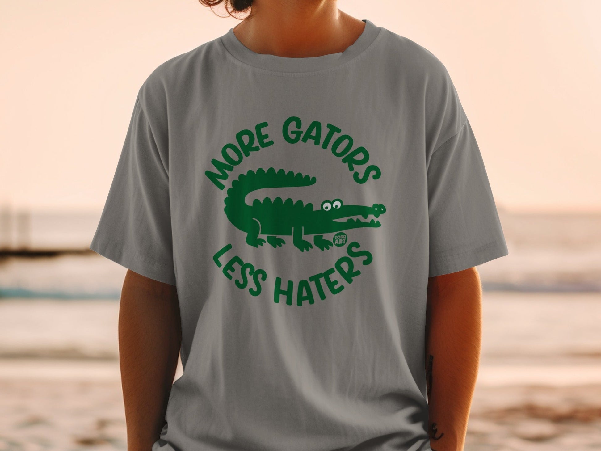 Grey t-shirt with green alligator graphic and text "MORE GATORS LESS HATERS".