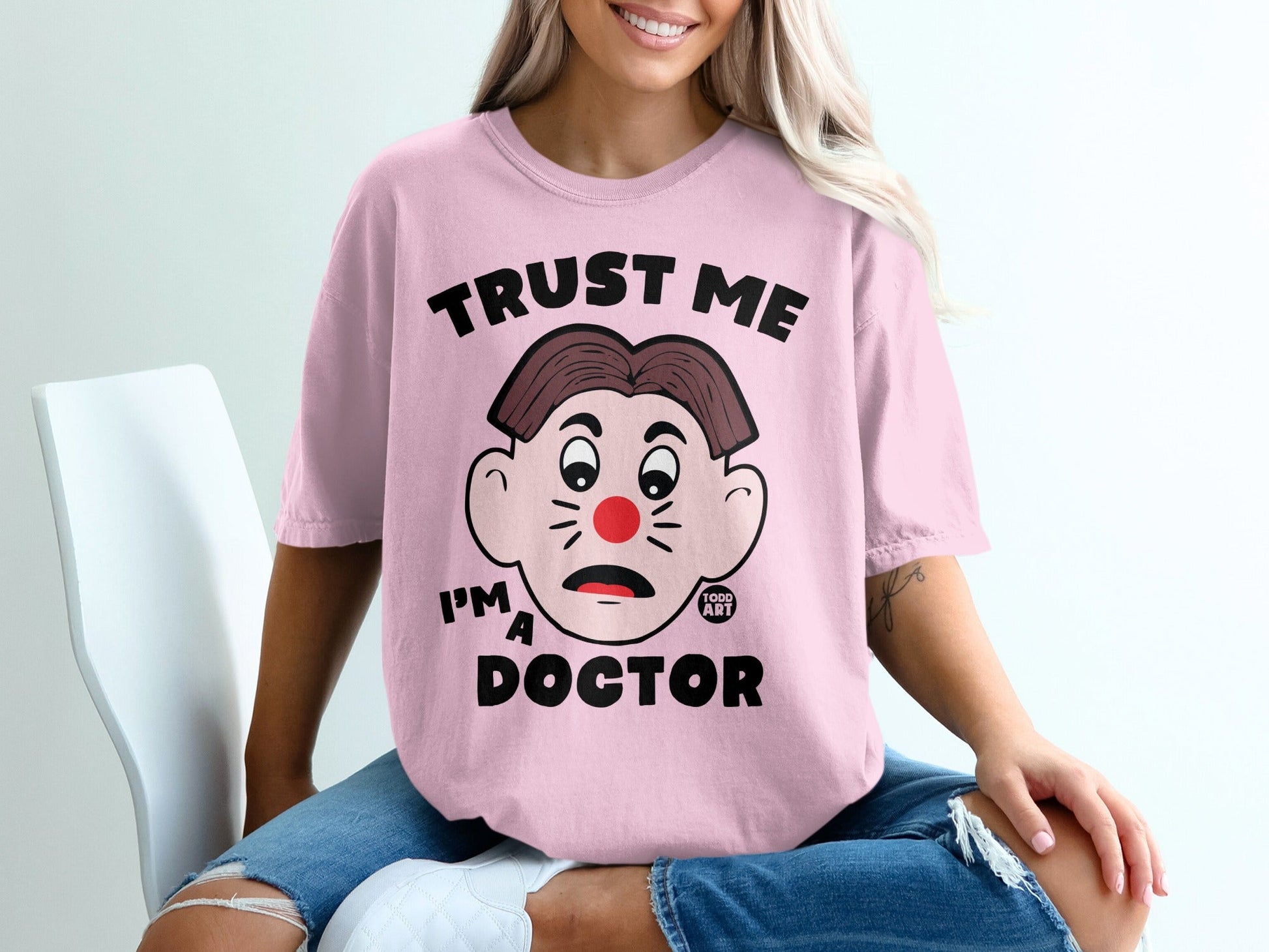 Pink t-shirt with "Trust me I'm a Doctor" and cartoon clown face.