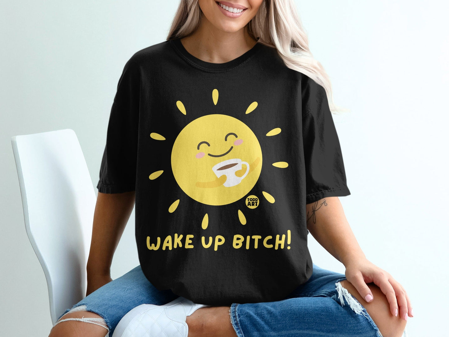 Black t-shirt with a smiling sun holding a coffee cup, text "WAKE UP BITCH!".