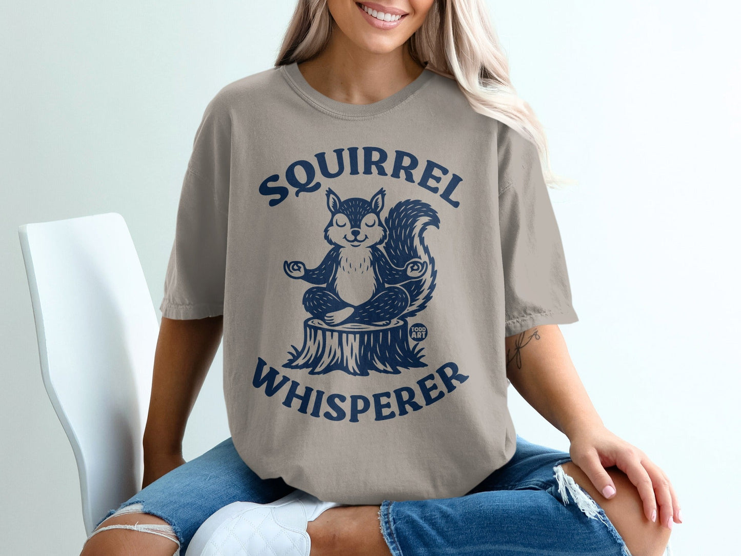 Tan t-shirt with a meditating squirrel and "Squirrel Whisperer" text.