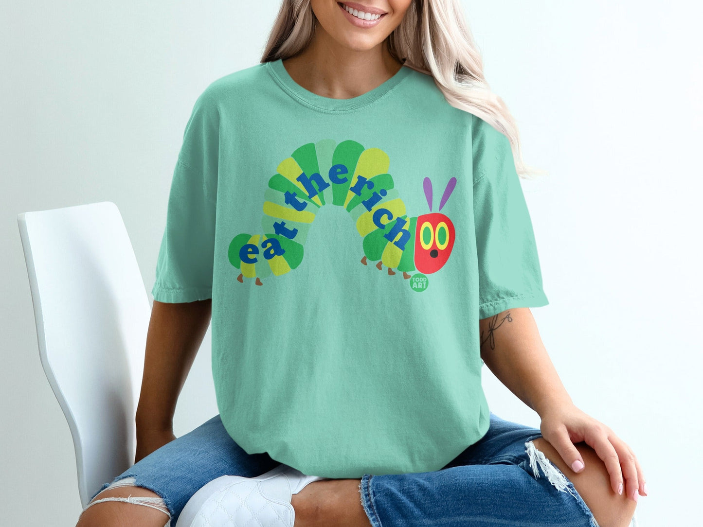 Green t-shirt with "Eat the Rich" caterpillar graphic and "Food Art" logo.