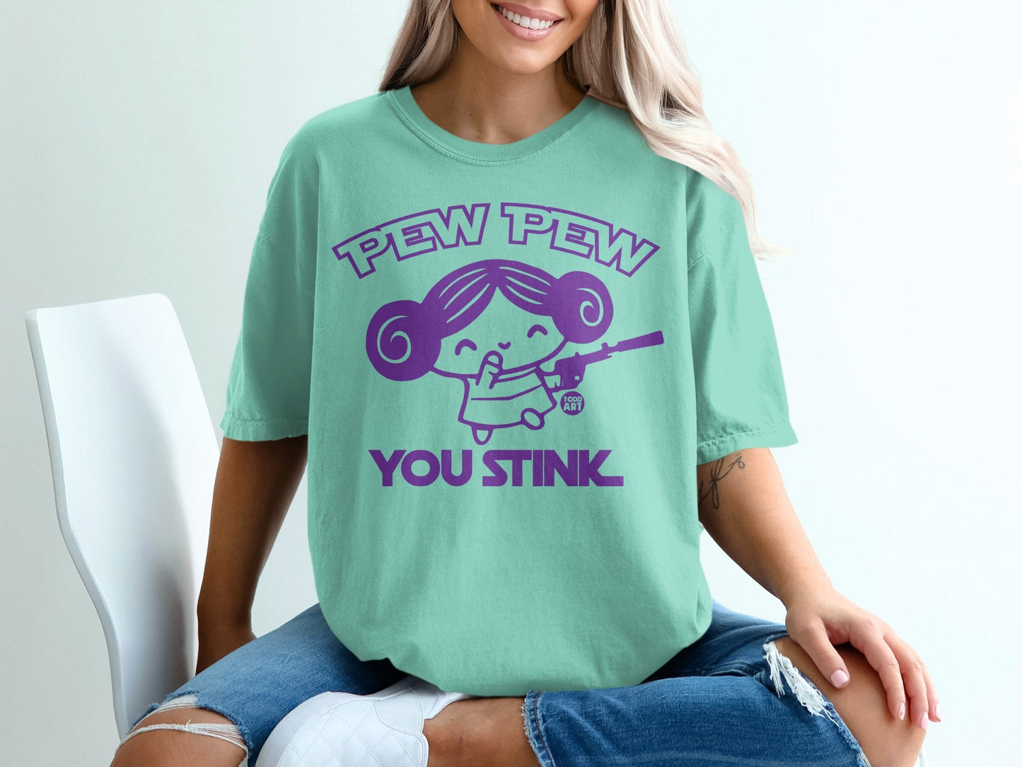 Mint t-shirt with purple "Pew Pew You Stink" text and cartoon character.