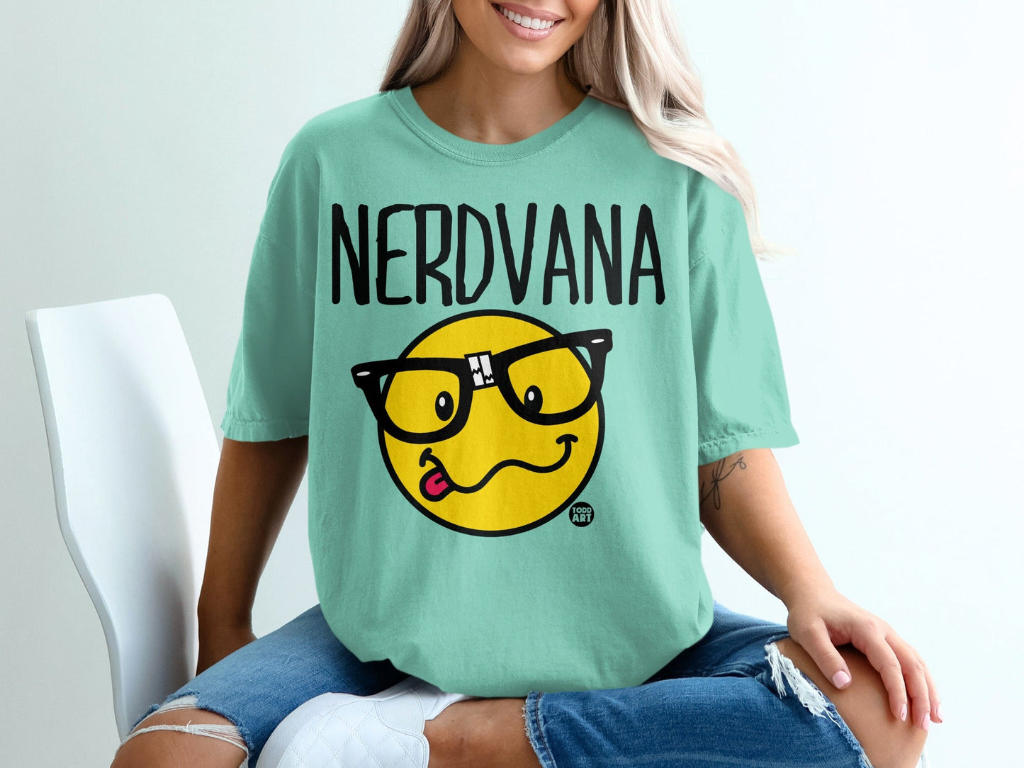 Mint t-shirt with "NERDVANA" text and a cartoon smiley face wearing glasses.