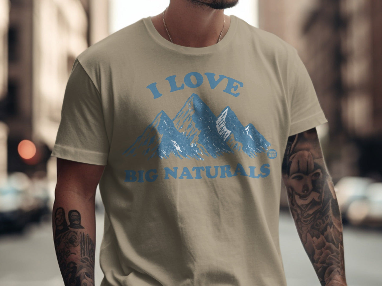 Tan t-shirt with blue "I Love Big Naturals" mountain graphic.