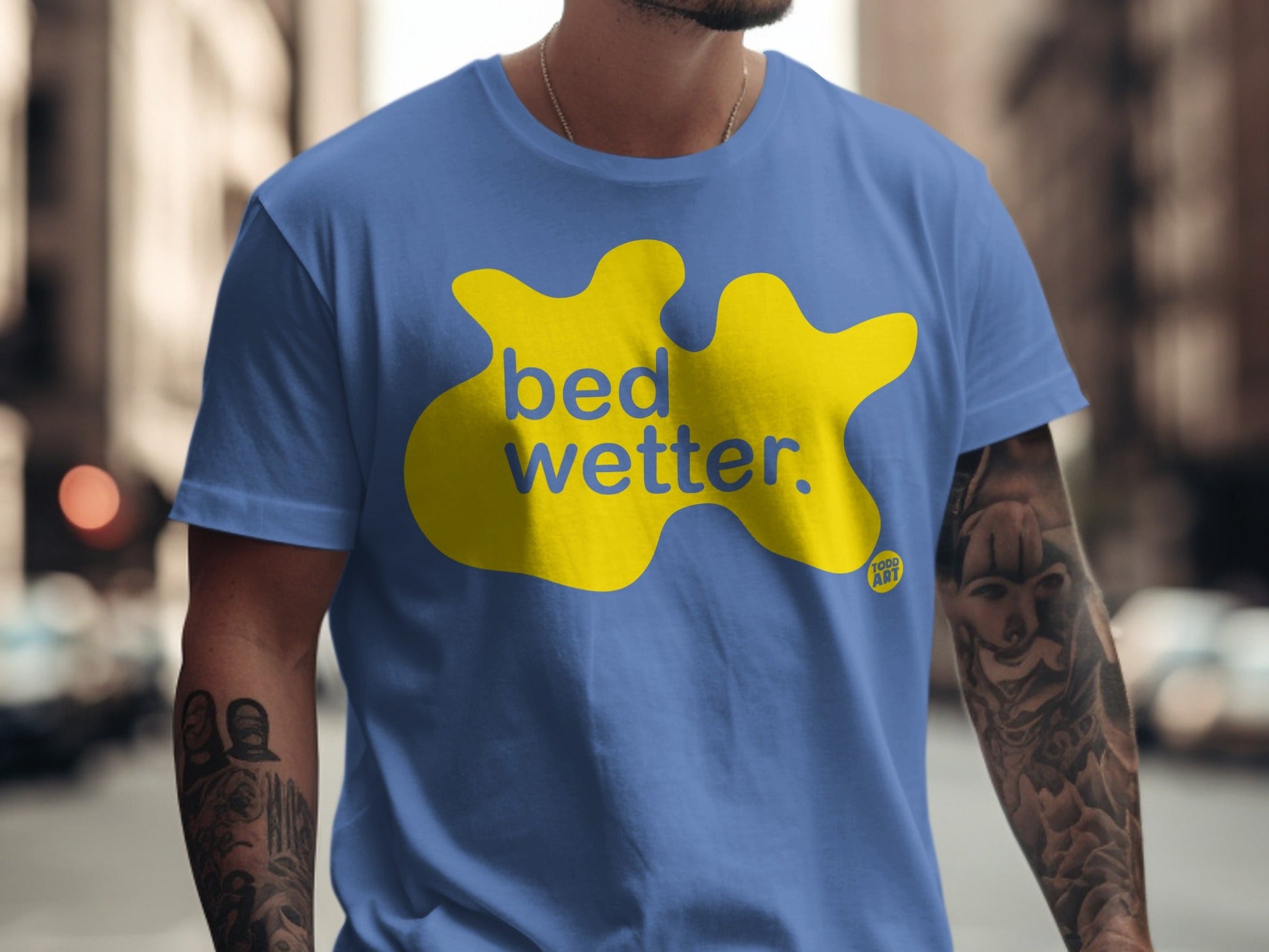 Blue t-shirt with yellow "bed wetter" graphic and "Too Cool" logo.