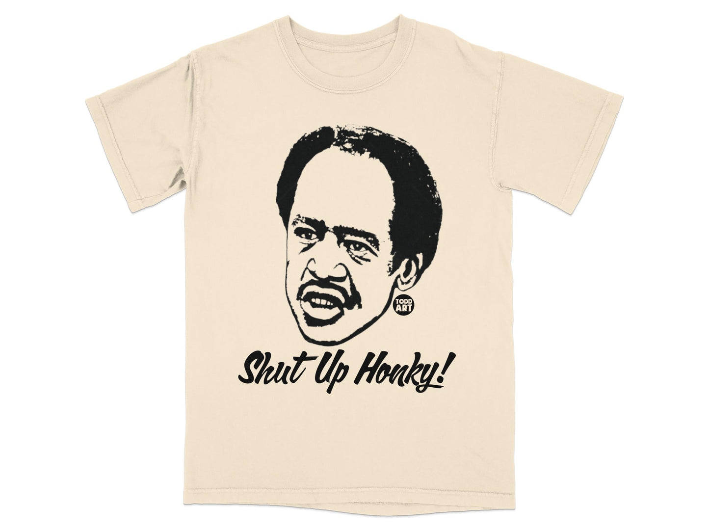 Cream t-shirt with a black graphic of a man's face and the text "Shut Up Honky!".