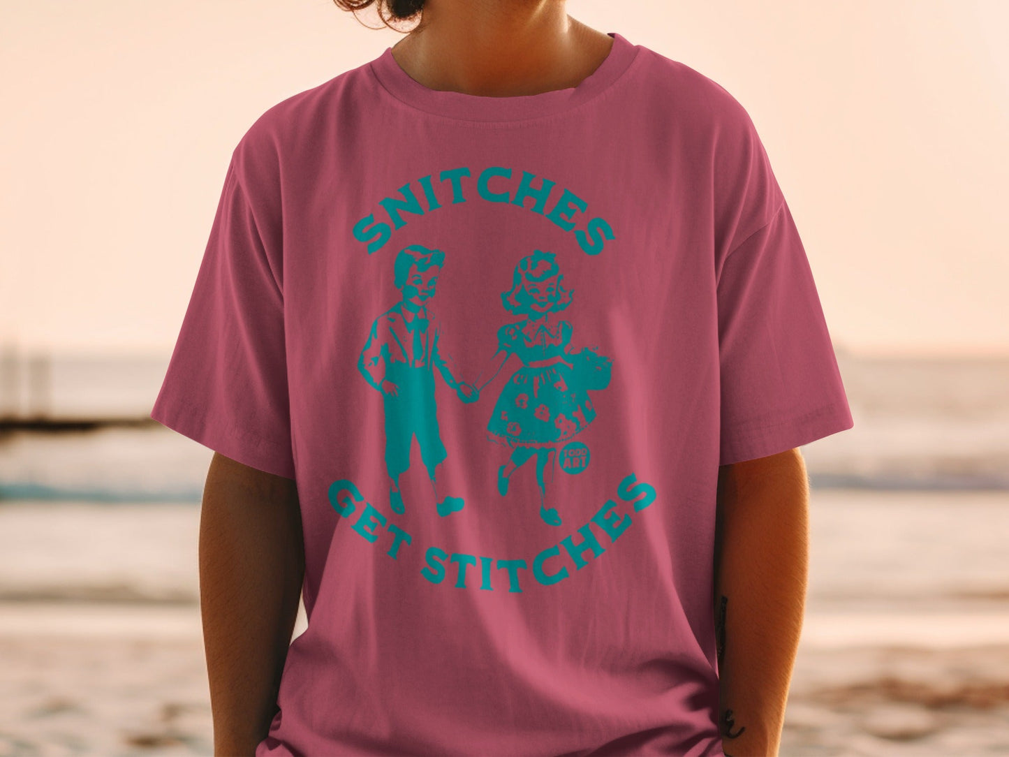 T-shirt with teal graphic of children and text "Snitches Get Stitches."