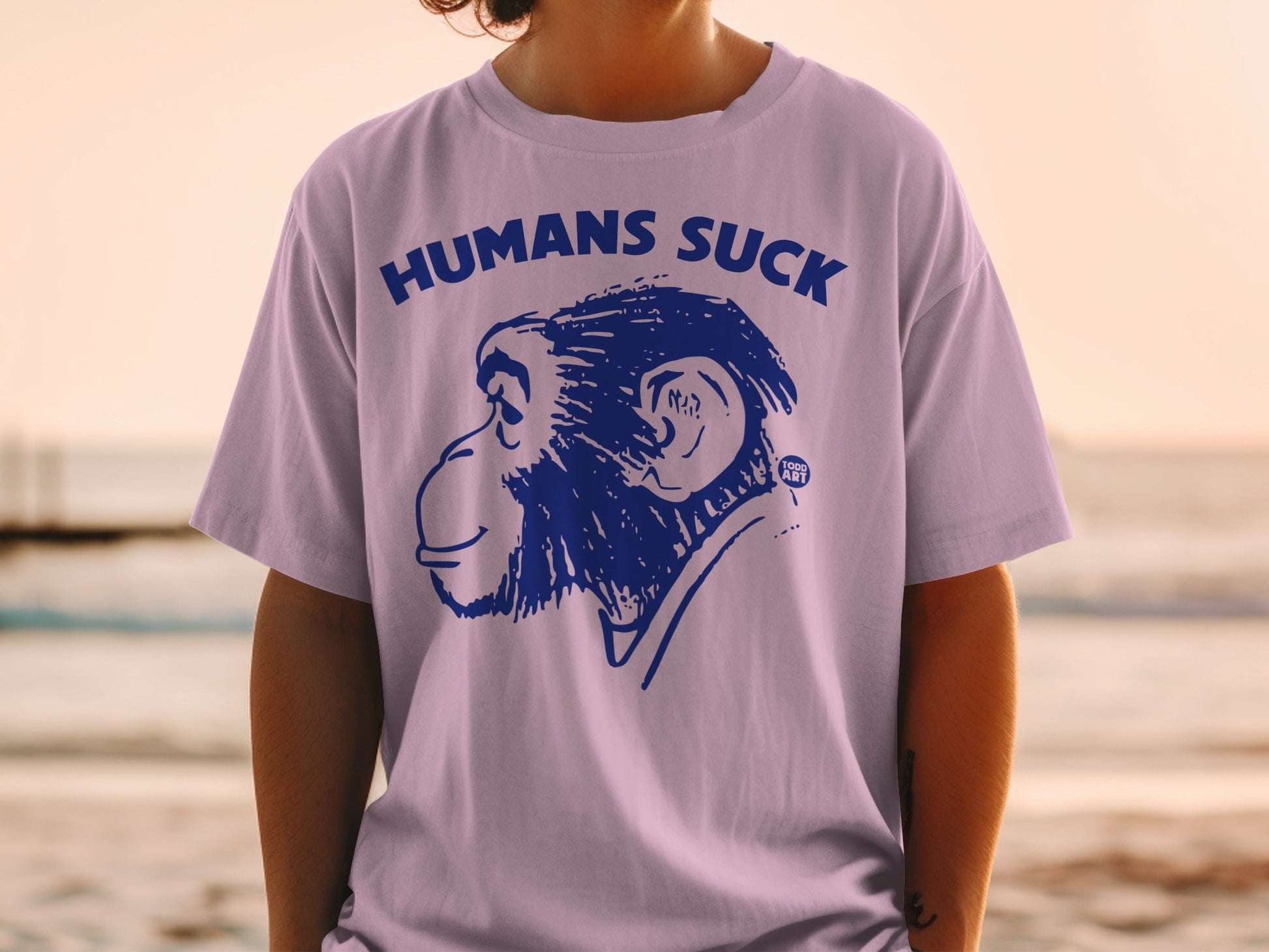 Purple t-shirt with blue monkey graphic and "HUMANS SUCK" text.