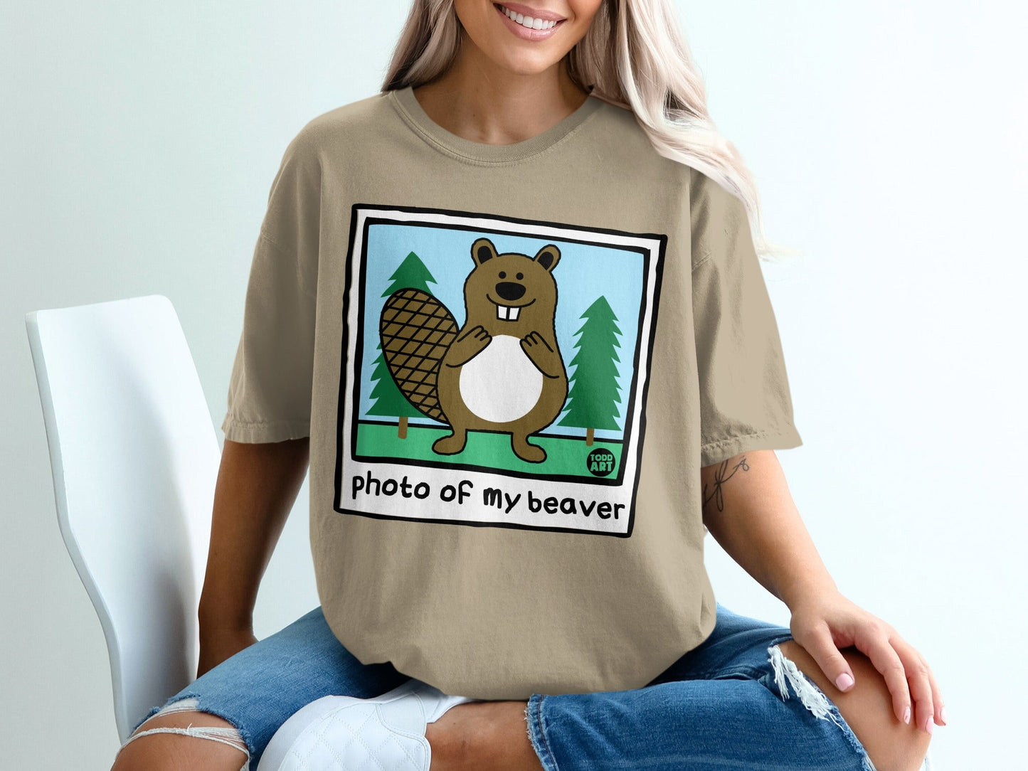Beaver illustration on a tan t-shirt with trees and text "photo of my beaver".